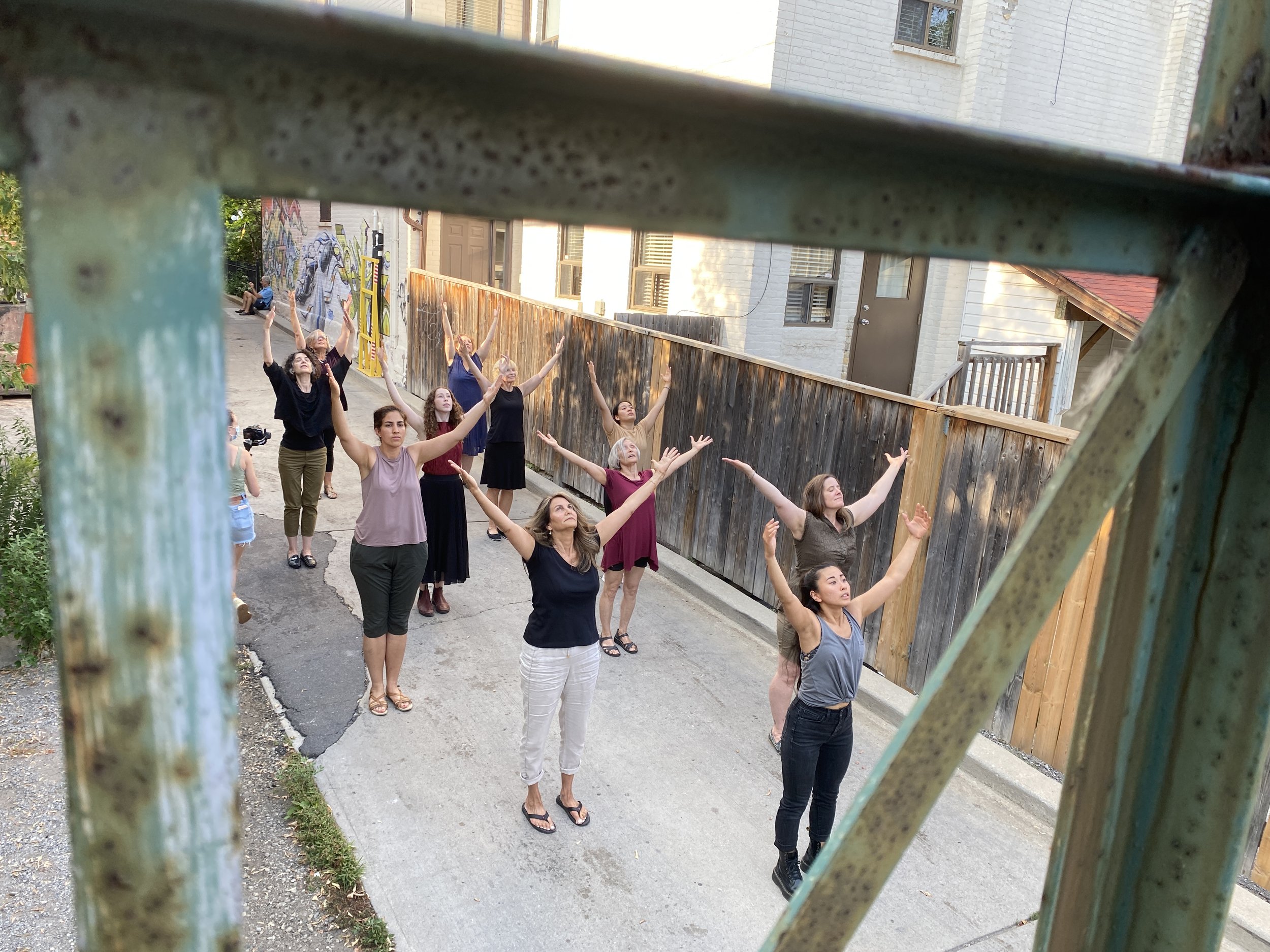 Community Participants with arms reaching overhead