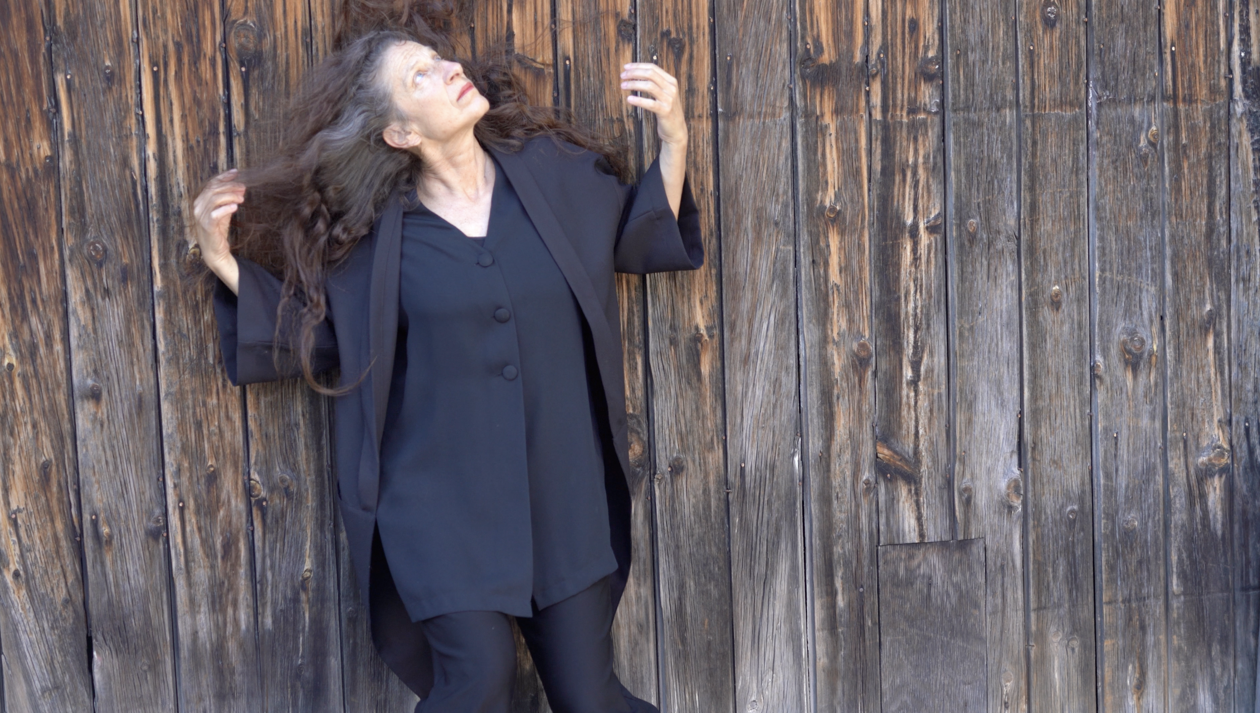 Karen Kaeja stands against a fence looking upwards