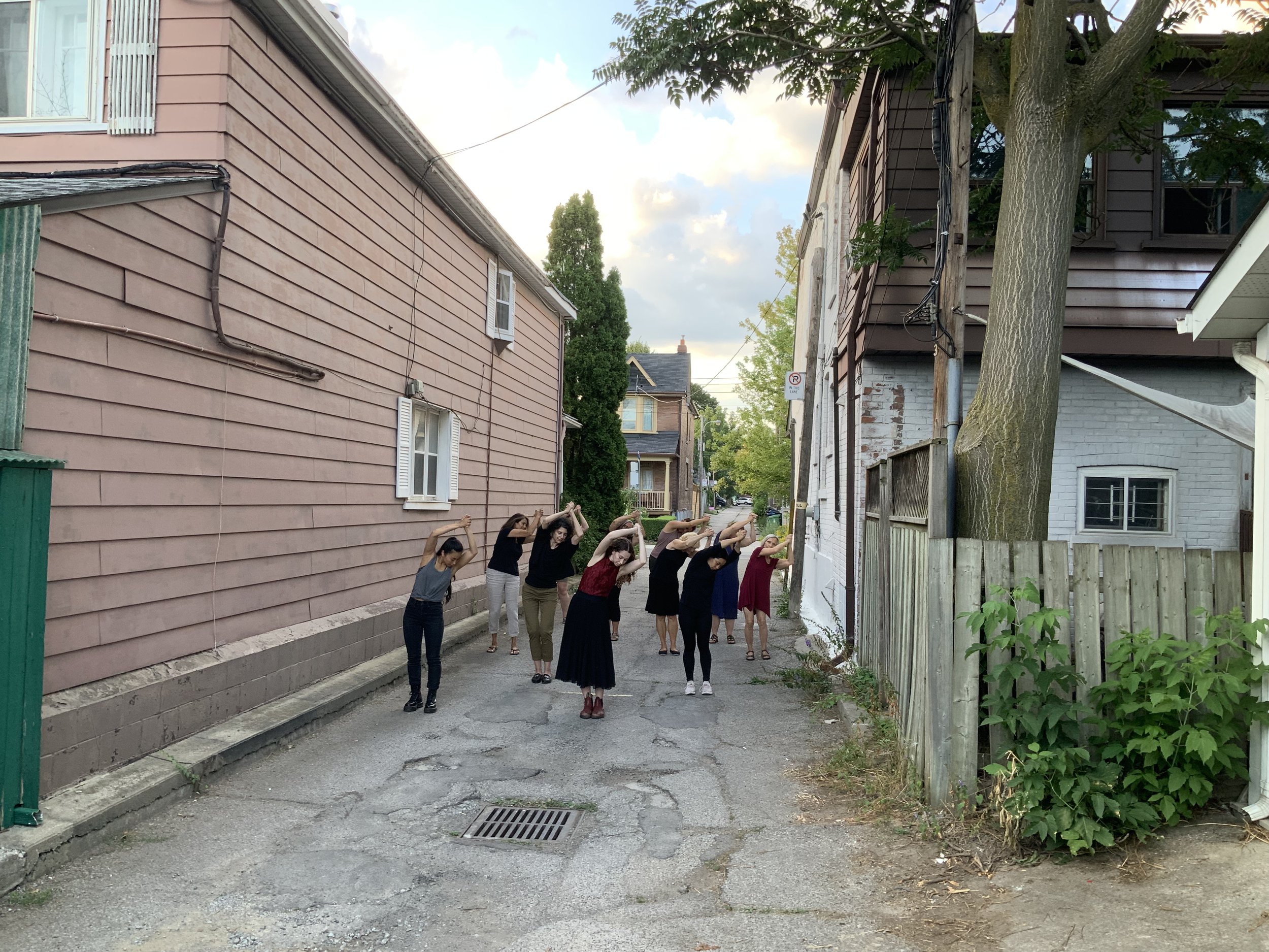 Community Participants with hands clasped over their heads.