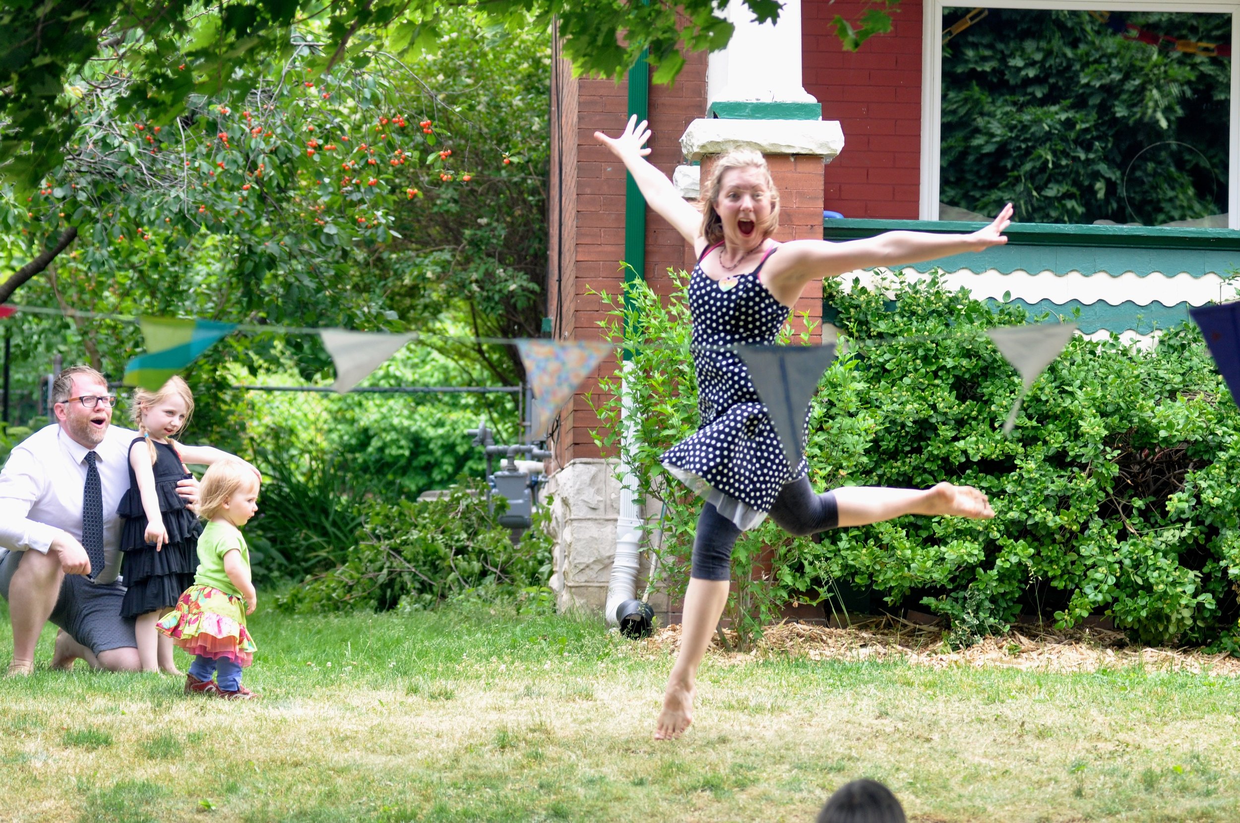 A community participant dances on a front lawn.