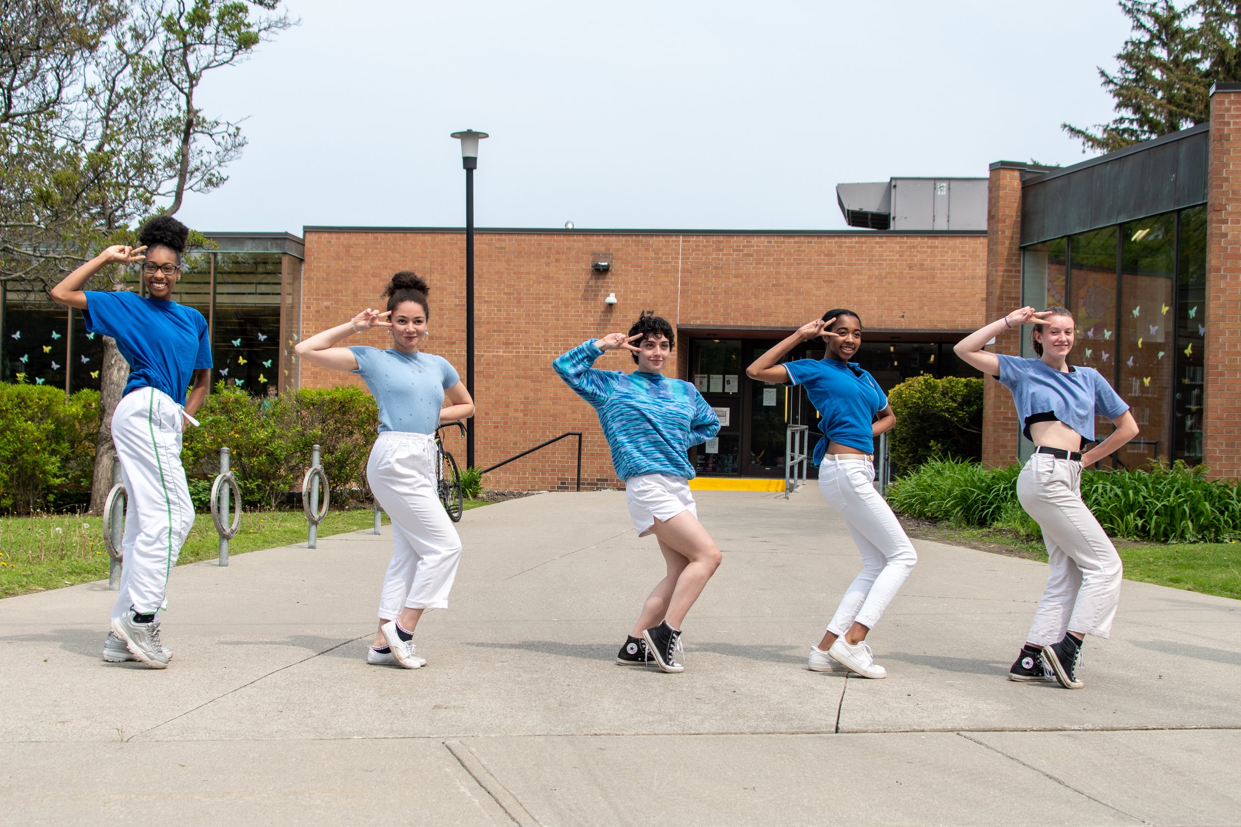 A group of young participants strike identical poses.