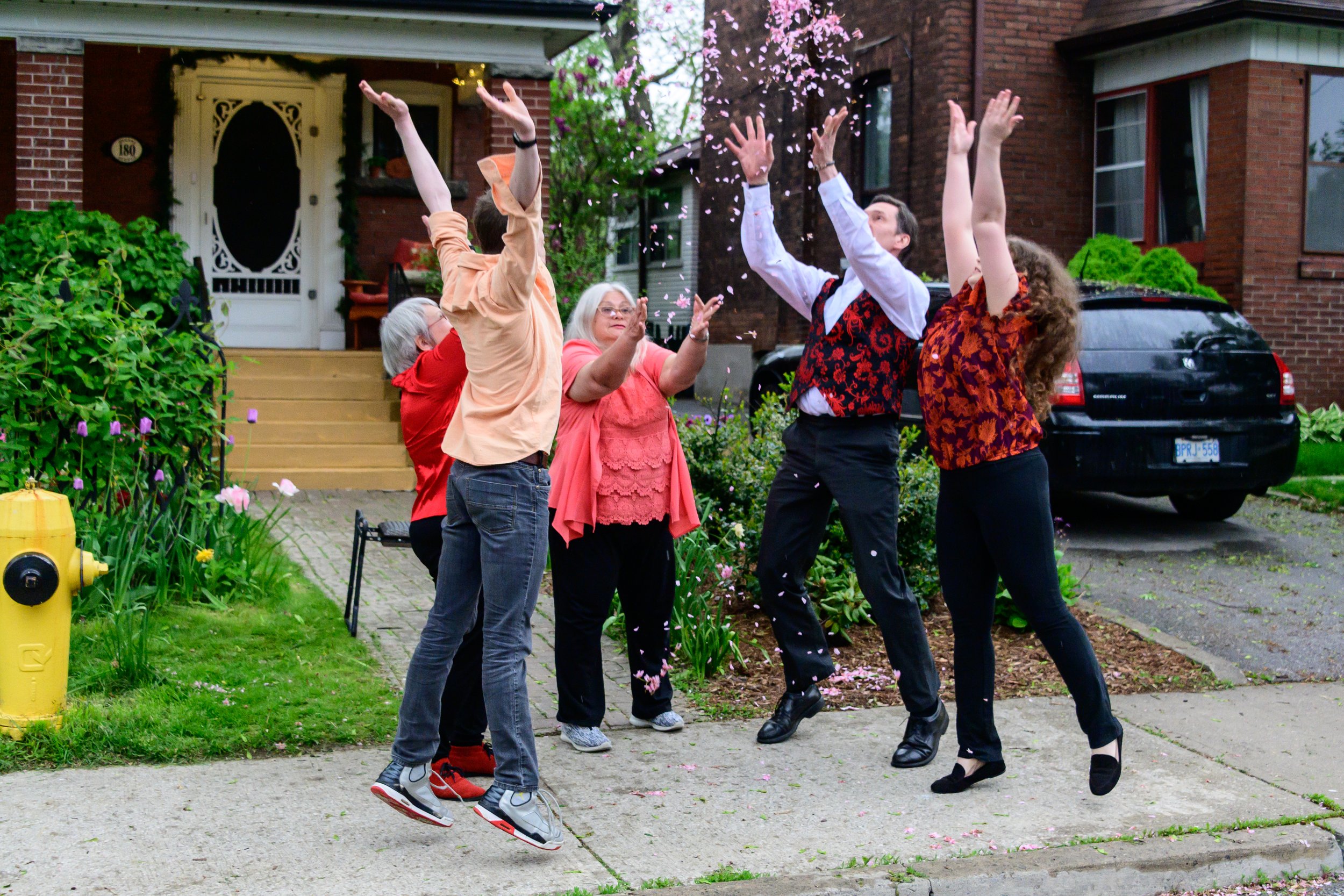 A group of participants throw flower petals in the air.