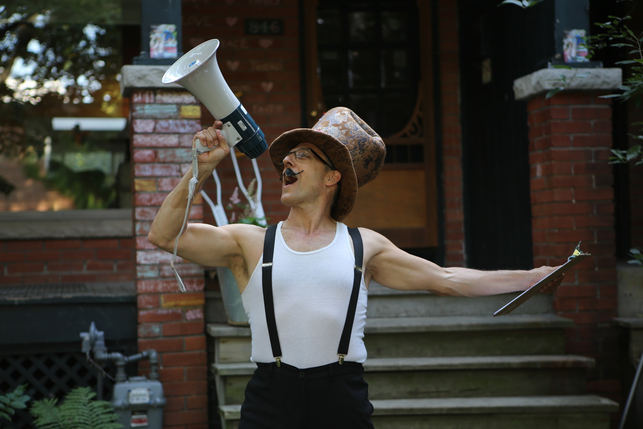 Man yelling into a megaphone, while holding a clipboard
