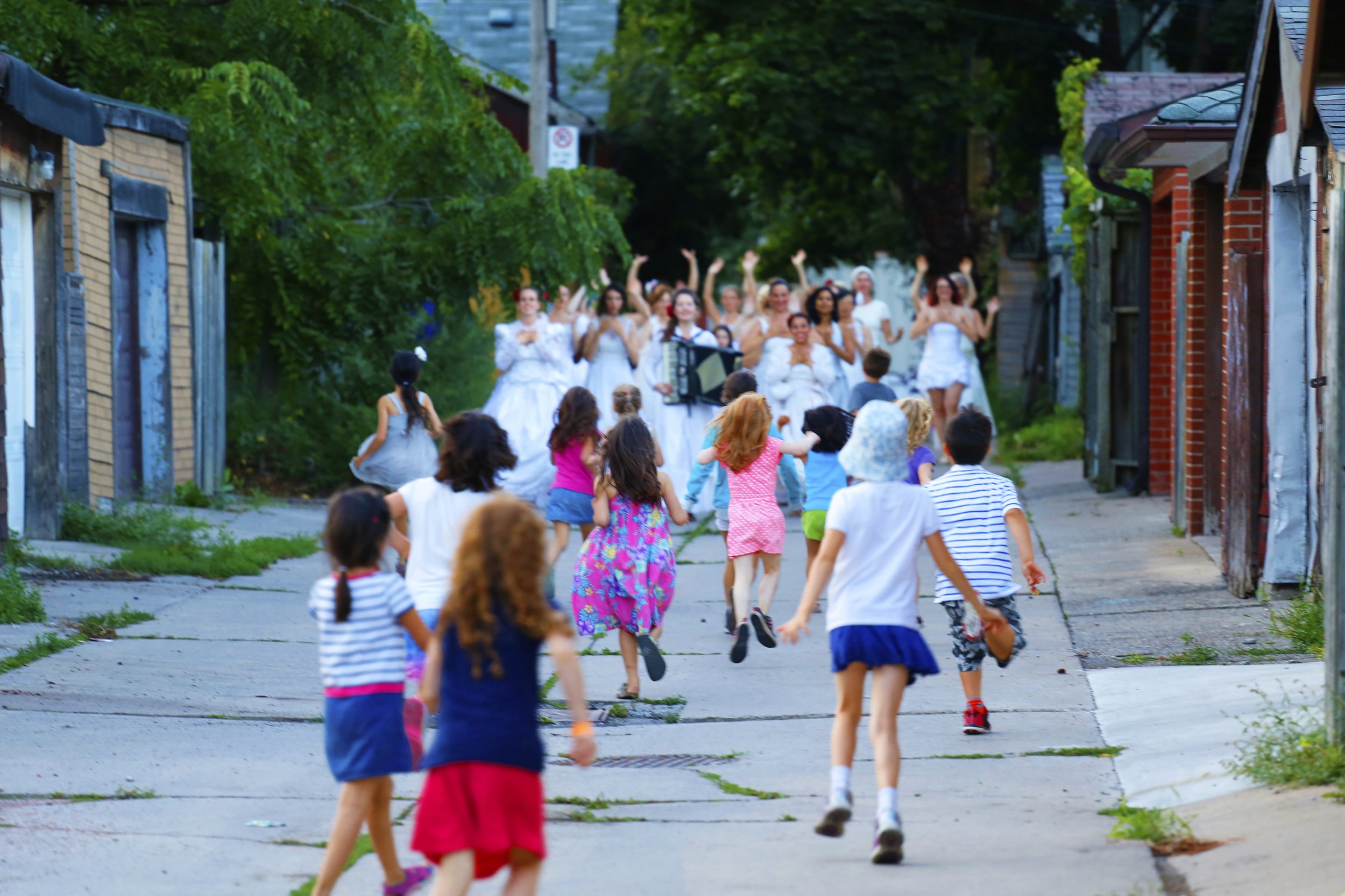 A large group of children running towards the wedding brigade