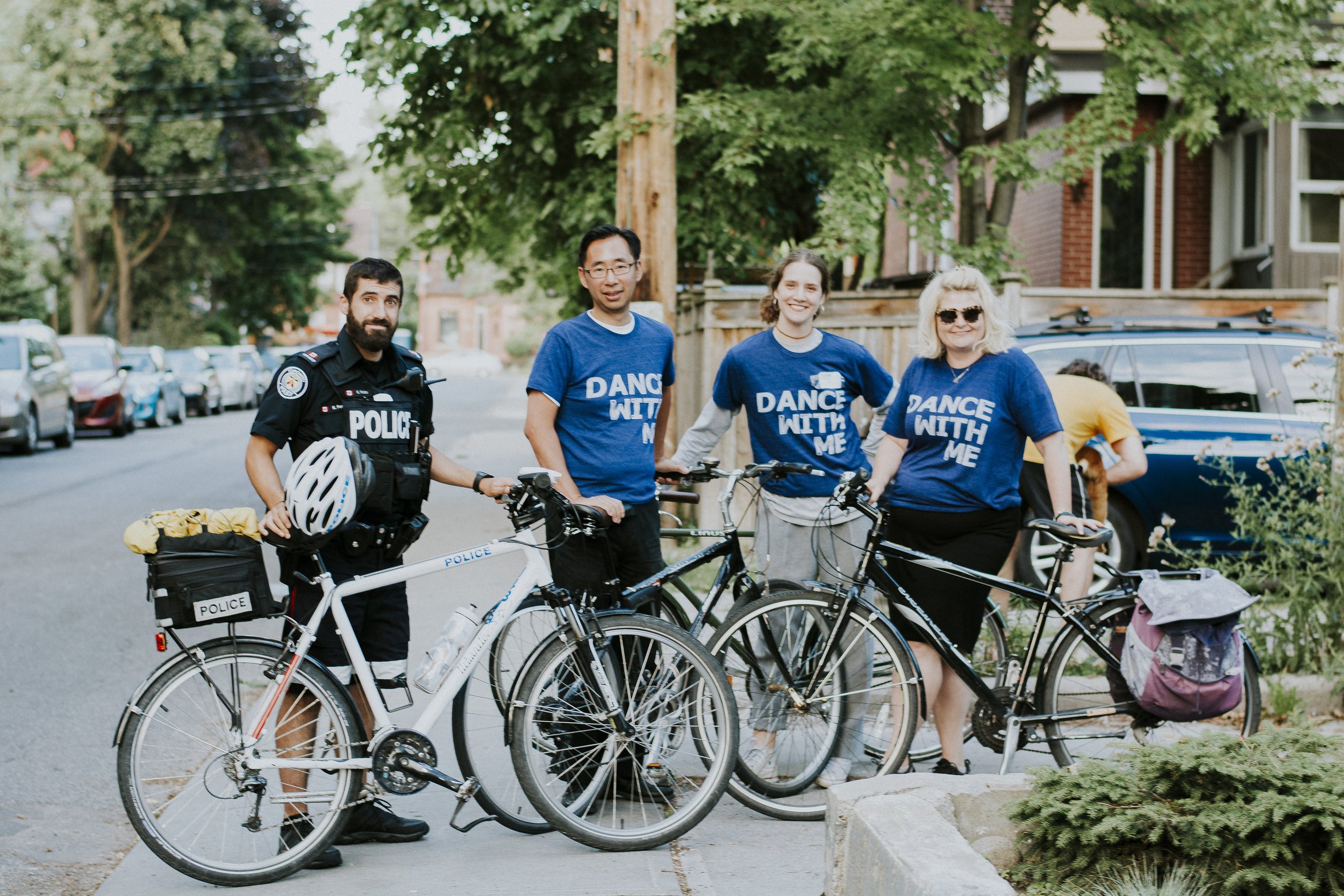 Toronto Police officer, and three participants posing happily with bikes