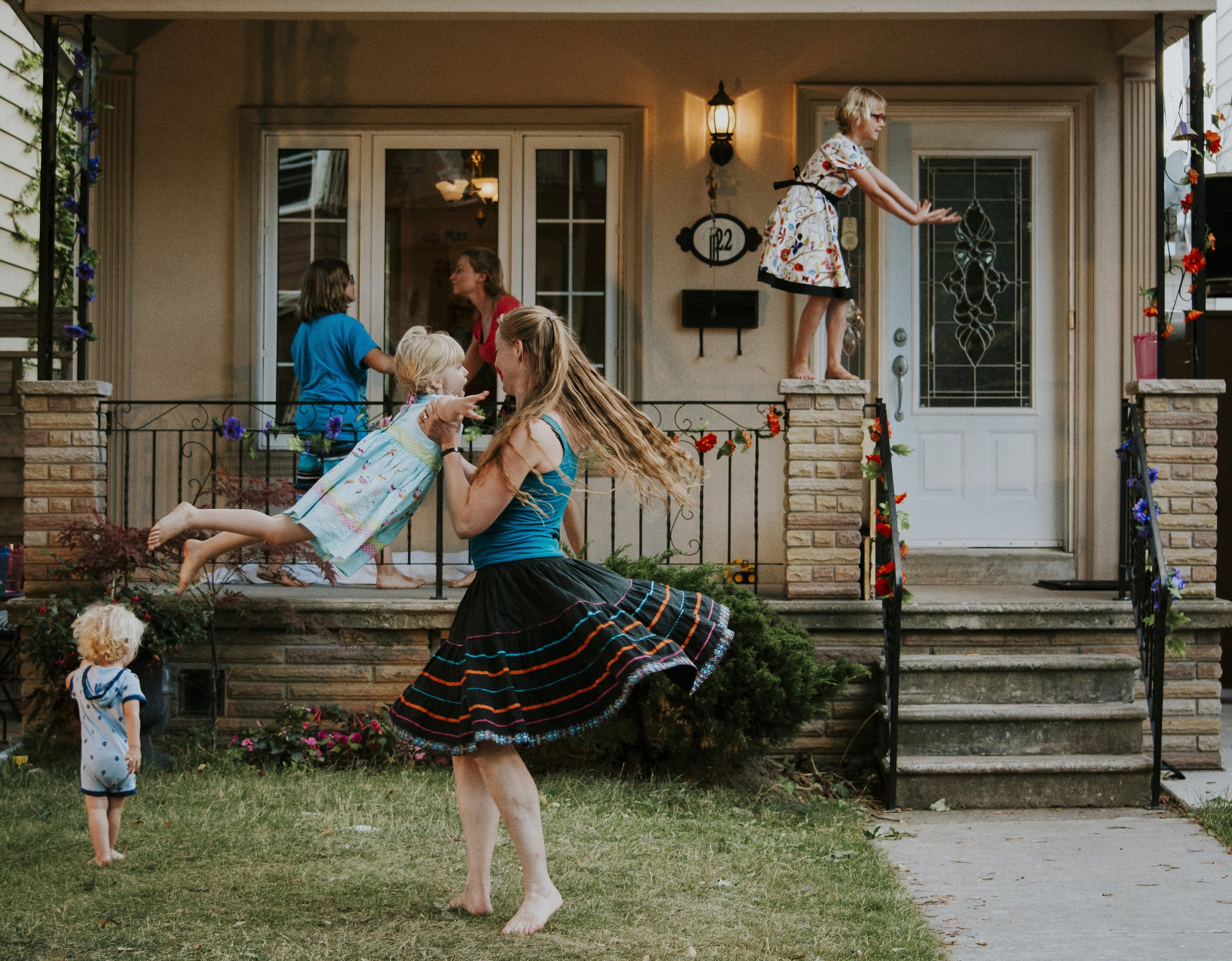 A family, each dancing happily all over their front porch