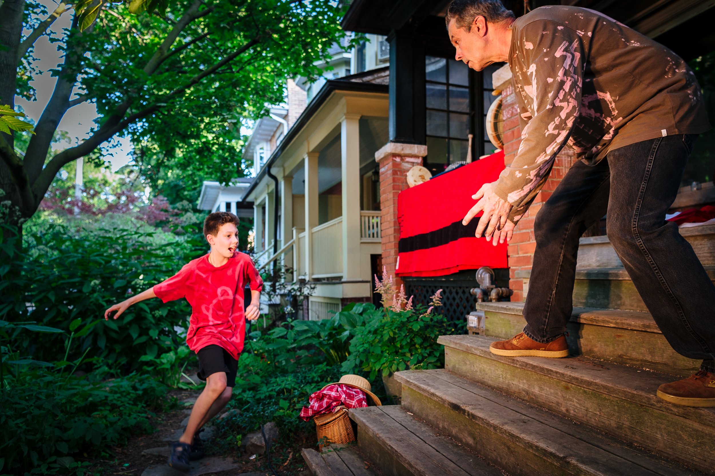 Boy runs to adult on porch who stands ready to embrace him