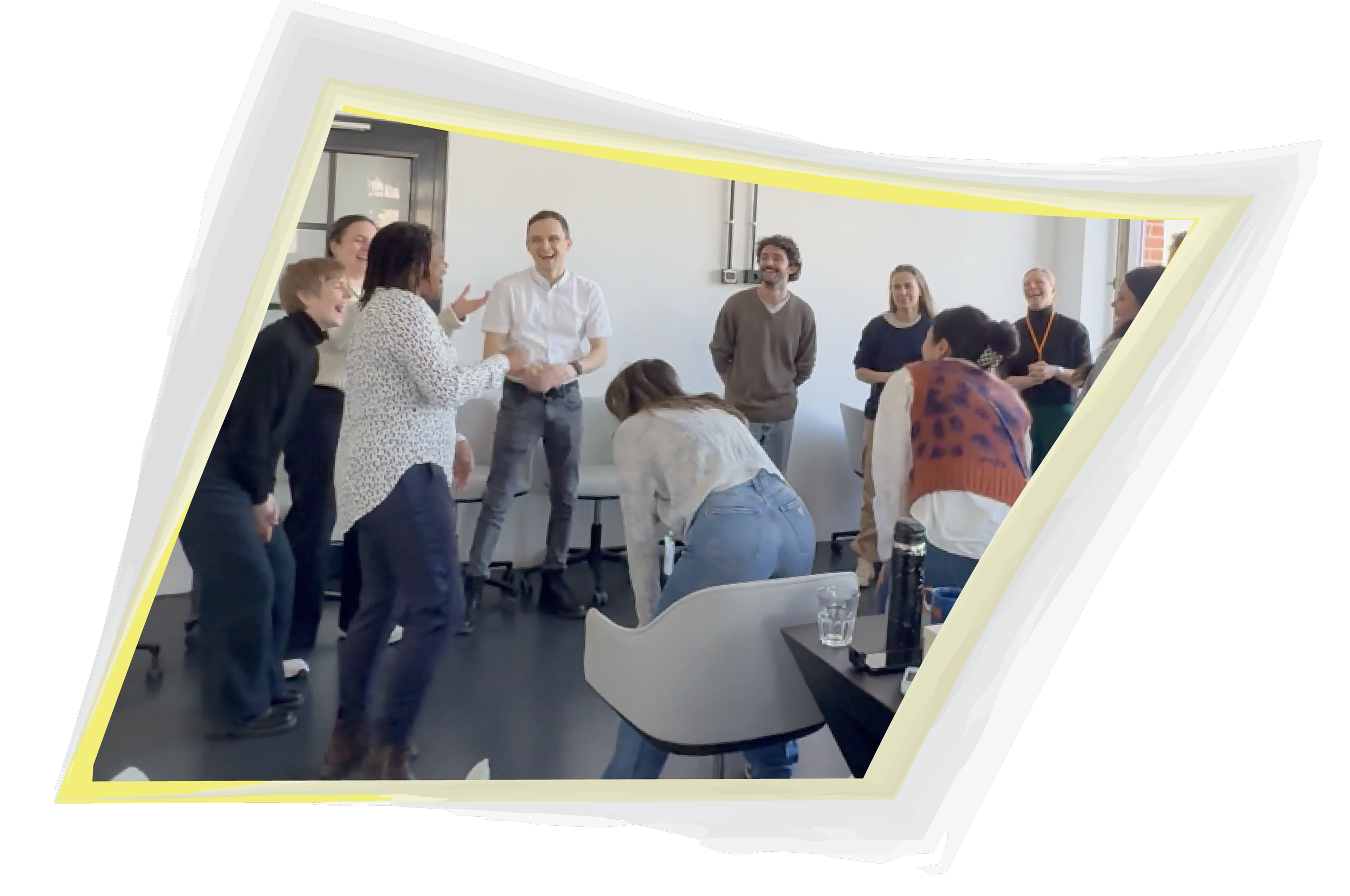 A circle of people huddled close, laughing and connecting with UnMake Your Box workshop leader, Veronica Louis