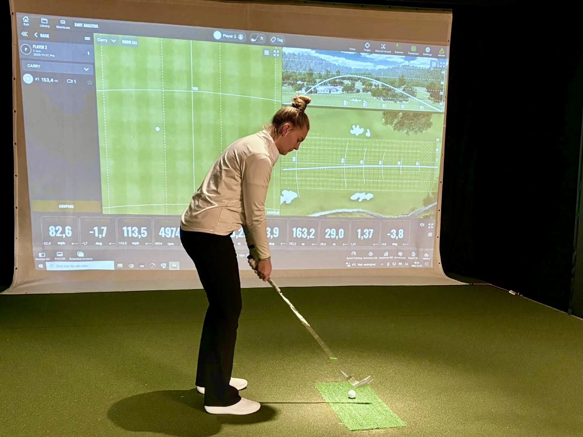 Golspelare spelar inomhusgolf med Trackman i Golfsimulator