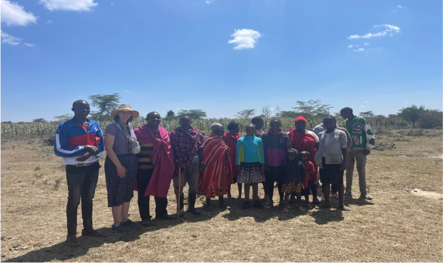 Group of 13 people in Kenya involved in the distribution of food provided in part by funds from Harvest of Talents via International Disaster Emergency Services. Colleen second from left.