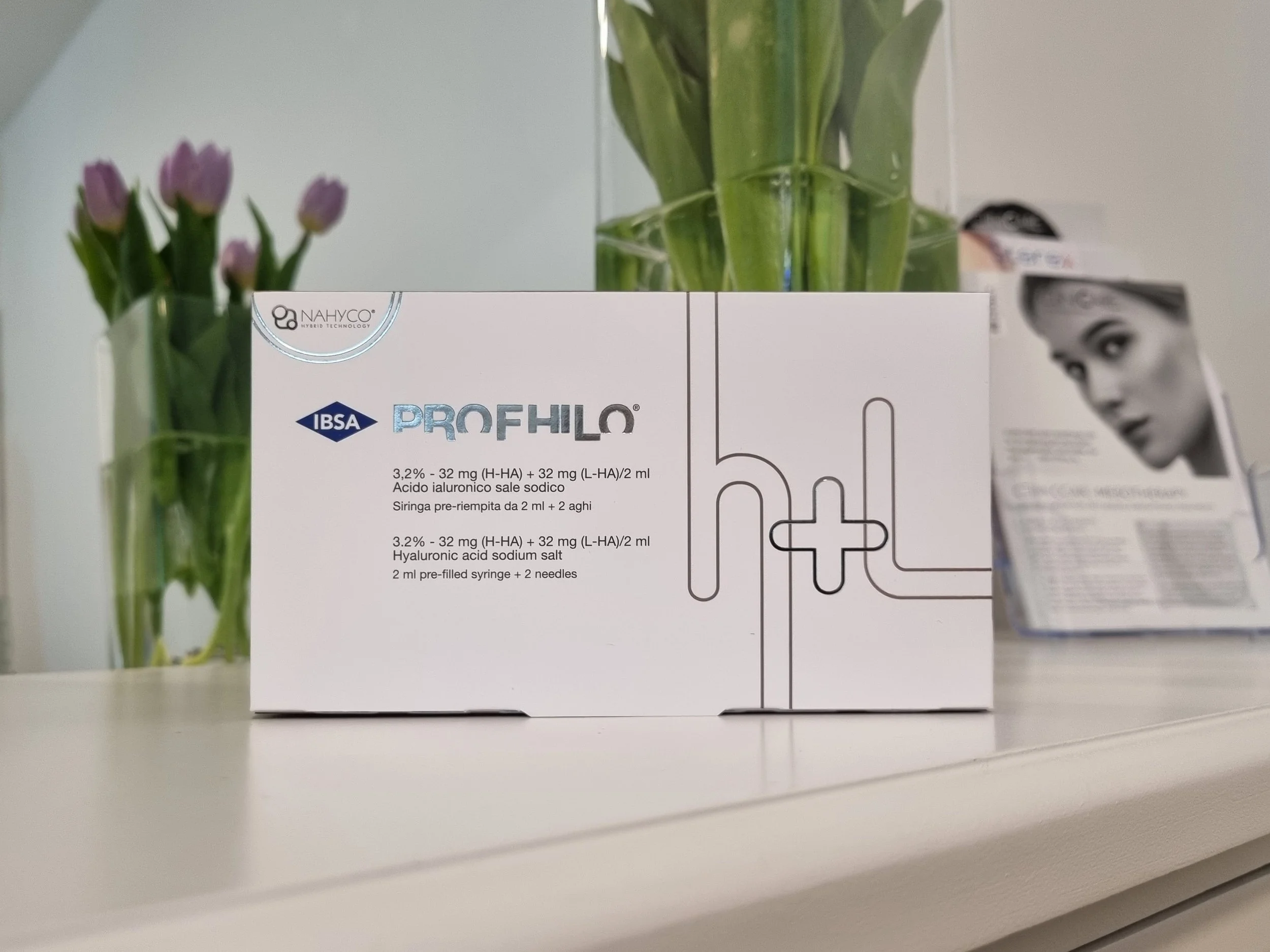 Box of Profhilo with a vase of tulips at the back