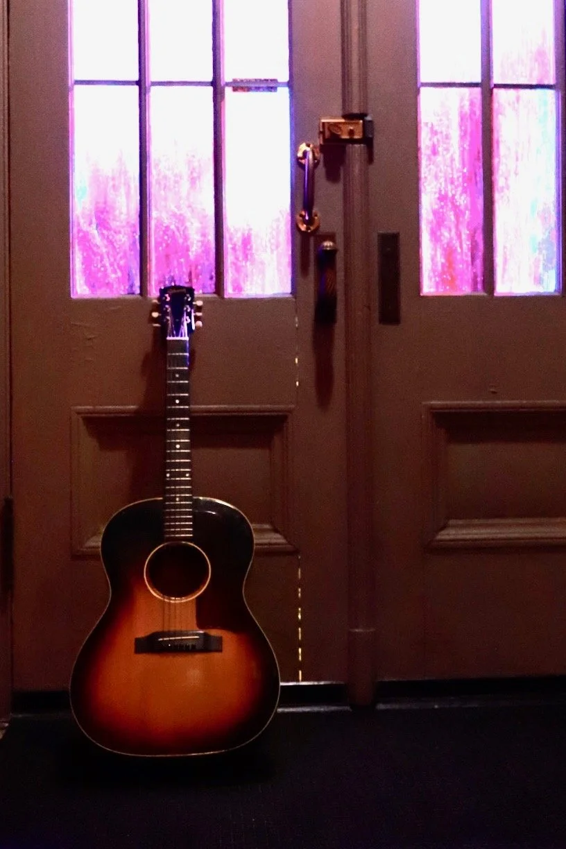 Guitar against purple windows in church.JPEG