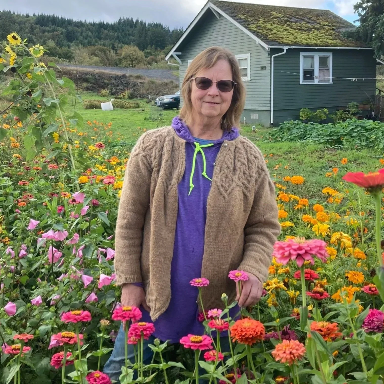 Woman wearing a straw hat and floral shirt, standing behind a checkout counter with a tablet-based point-of-sale system.