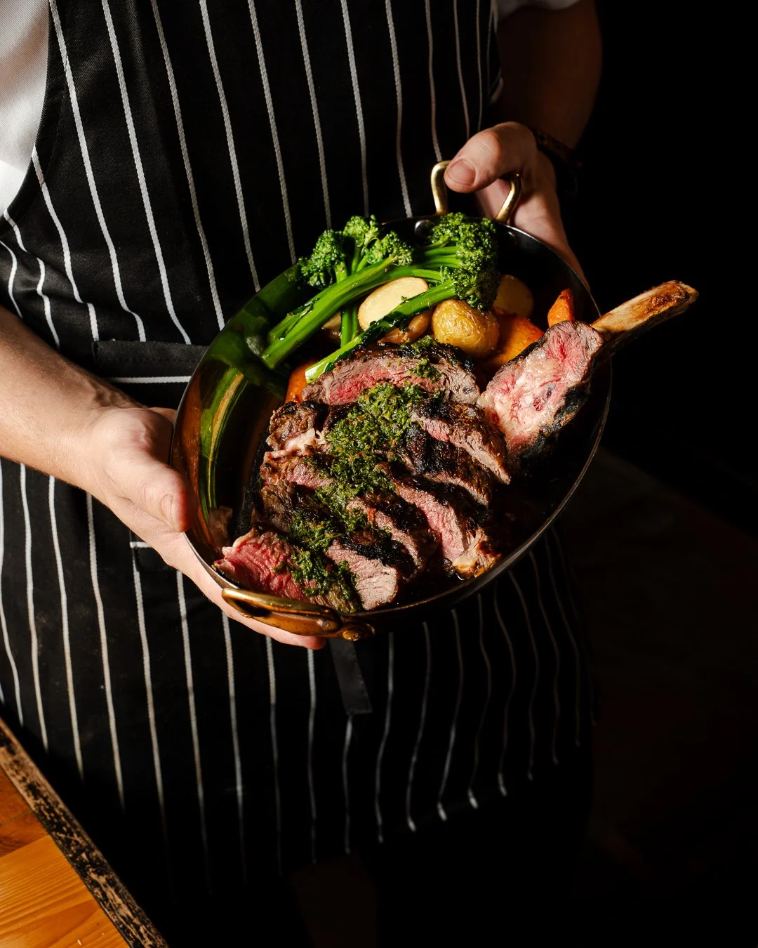 Rockwall Head Chef Nick Garth presenting pasture raised Tasmanian rib eye with roasted rosemary potatoes, carrots & broccollini.