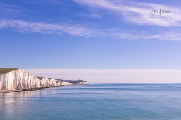 Seven Sisters cliffs and a calm blue sea, East Sussex, UK - Stoc