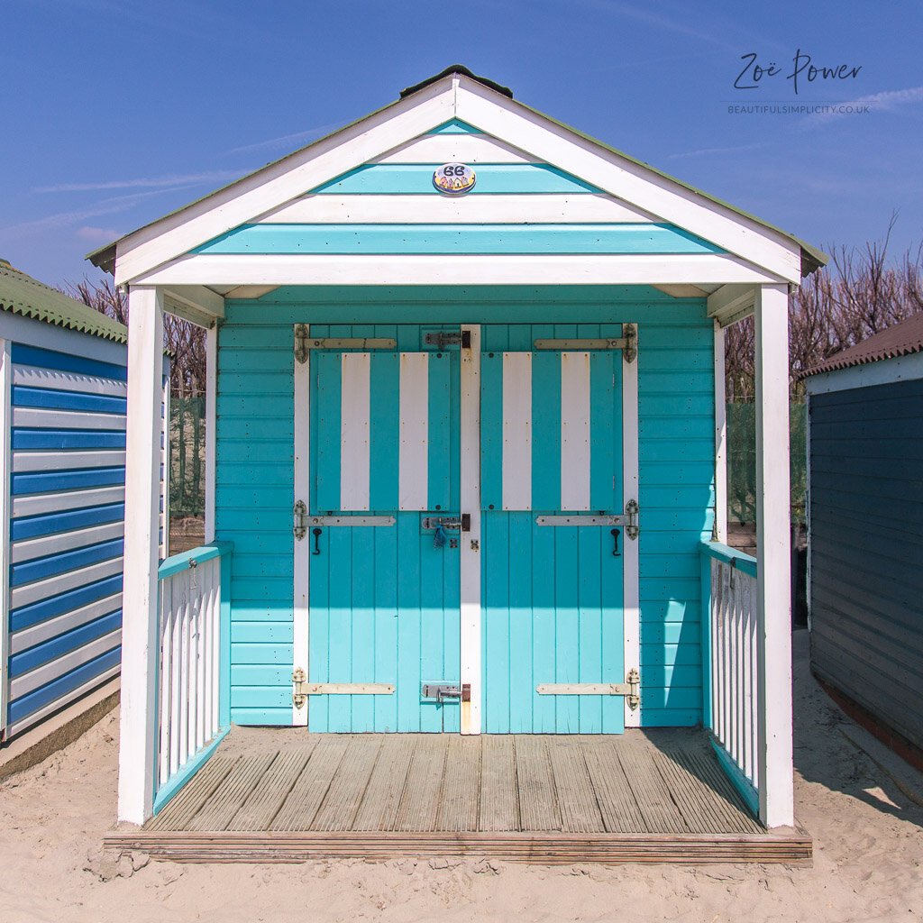 Turquoise stripey beach hut at West Wittering, West Sussex, UK -