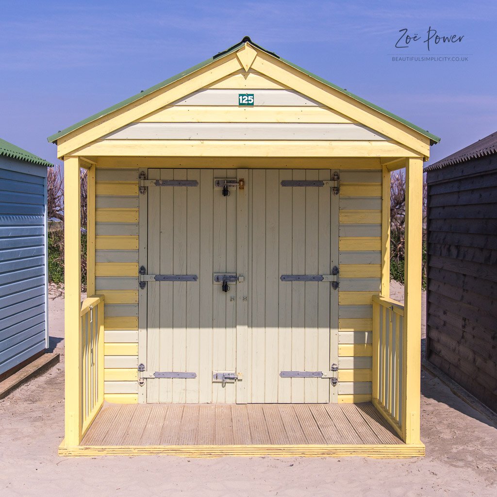 Stripey yellow and white beach hut on West Wittering beach - Sto
