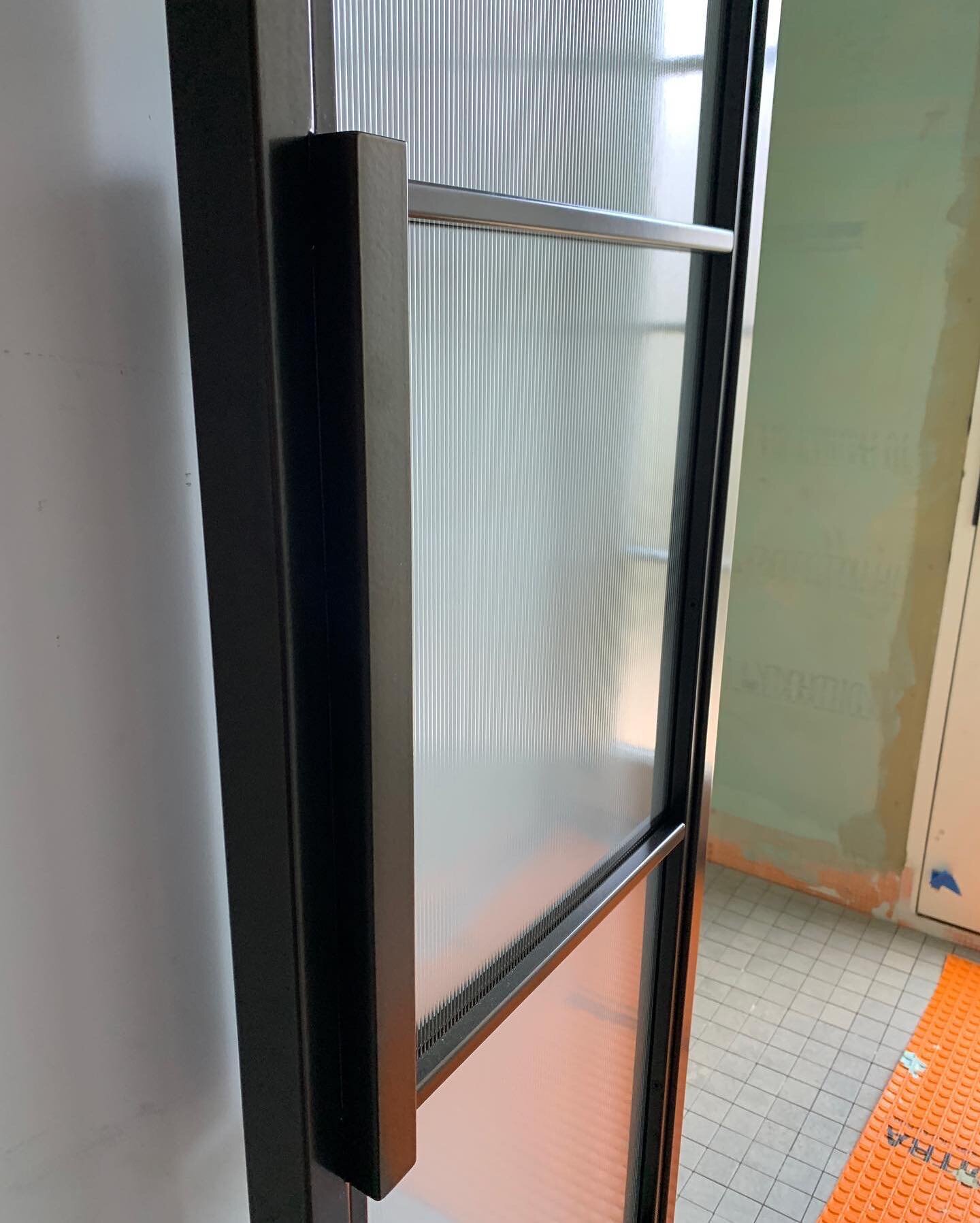 I was so stoked to see our custom @weldworkofficial french doors with reeded glass installed at the job site.  We have two sets of doors facing opposite each other: one leads to a toilet room and the other to a shower room.  I can&rsquo;t gush enough