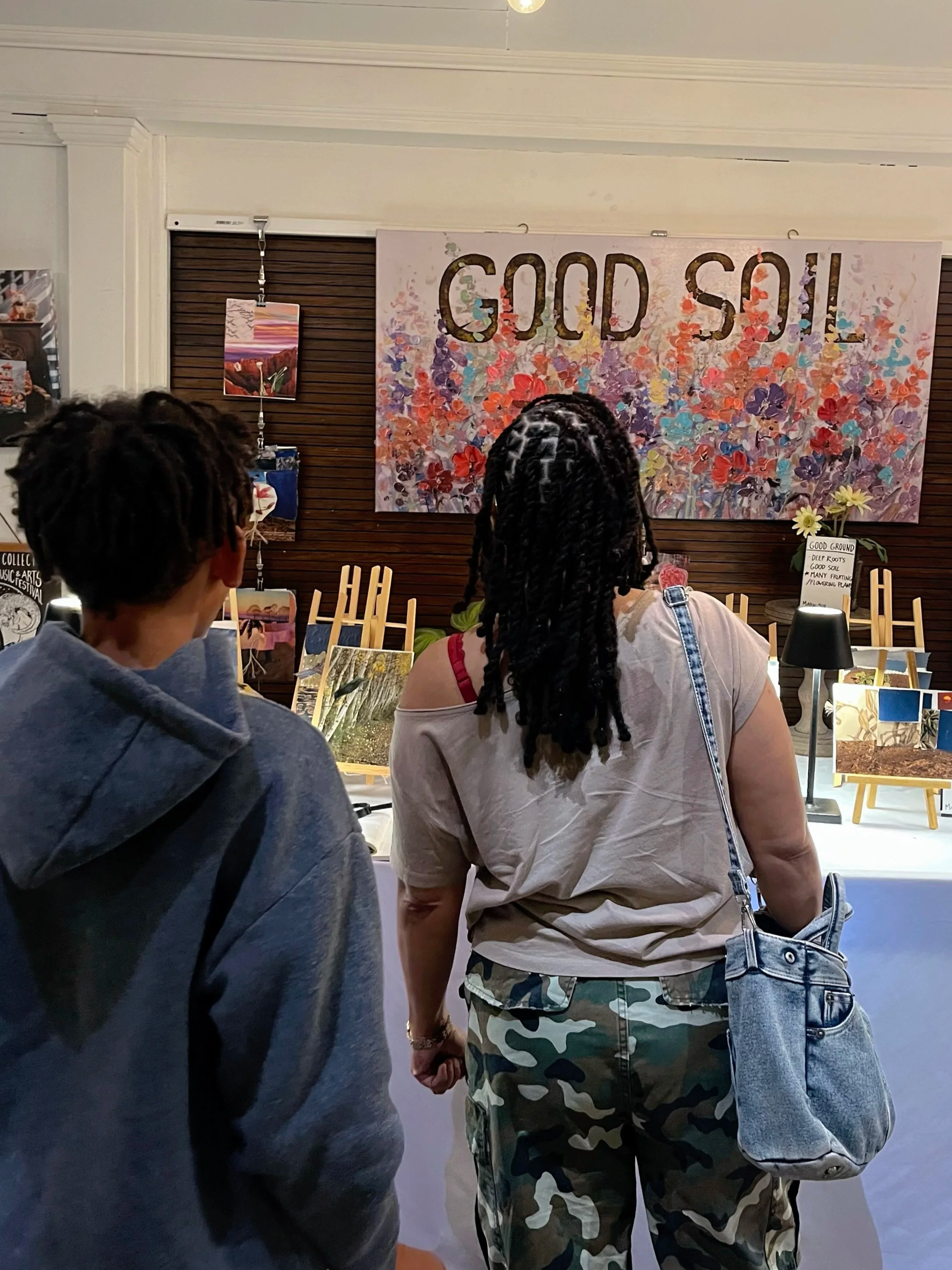   A student &amp; his mother view artwork depicting The Parable of the Sower  