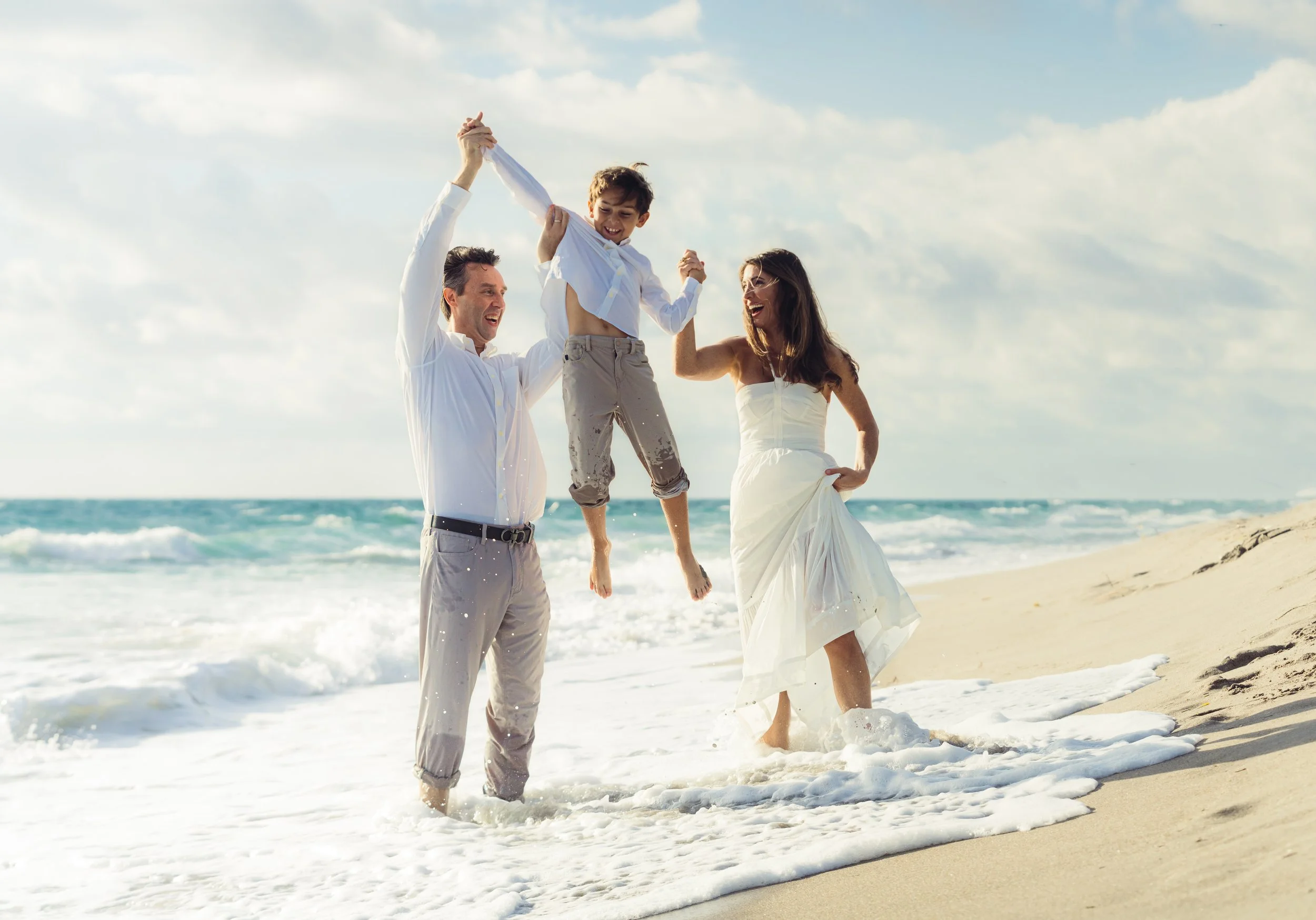 Sunrise beach family photos with children playing by the water.