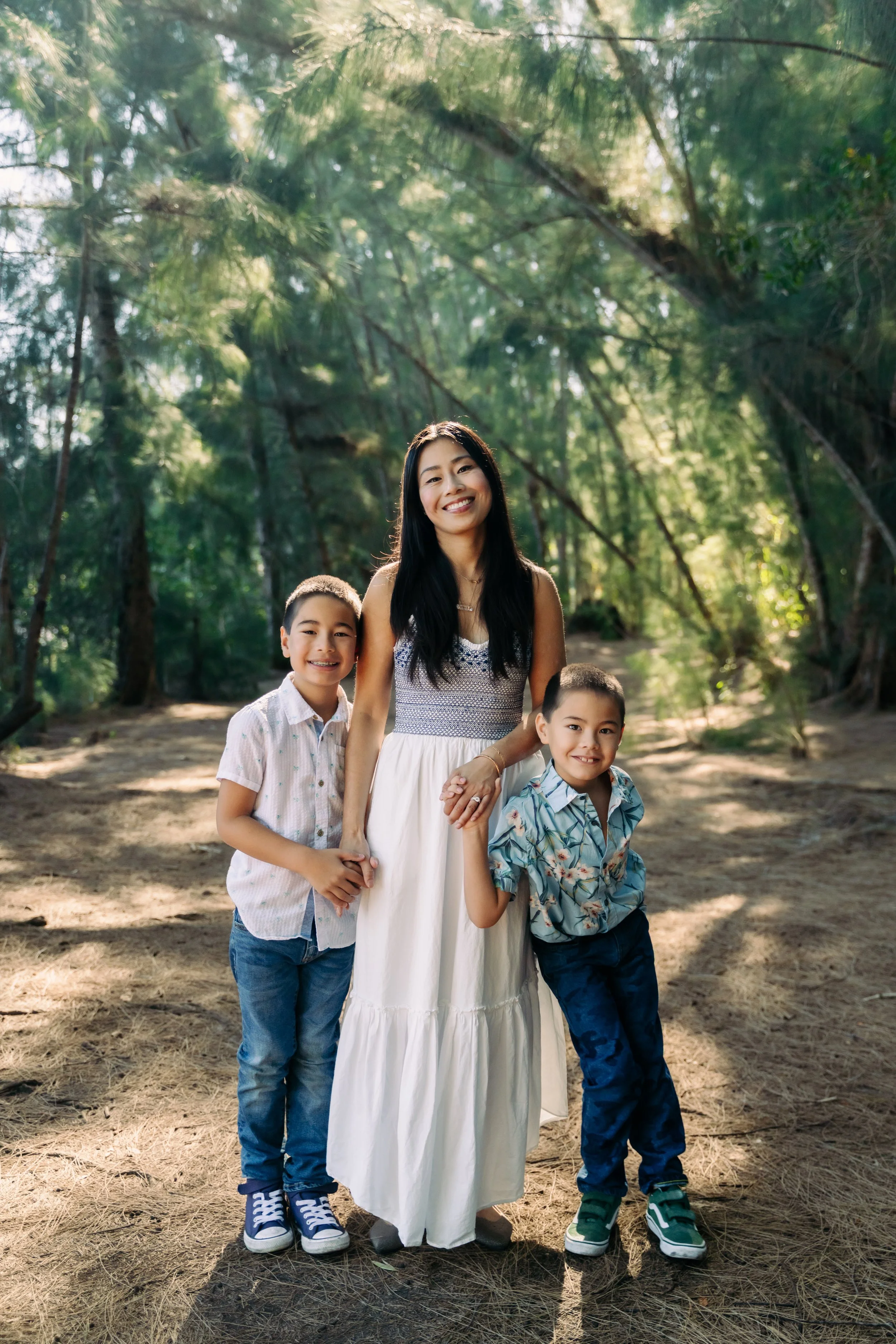 Family portrait of a mother with her two sons on a shaded wooded trail at Markham Park. Warm, candid family photo by Stephen Luttinger Photography.