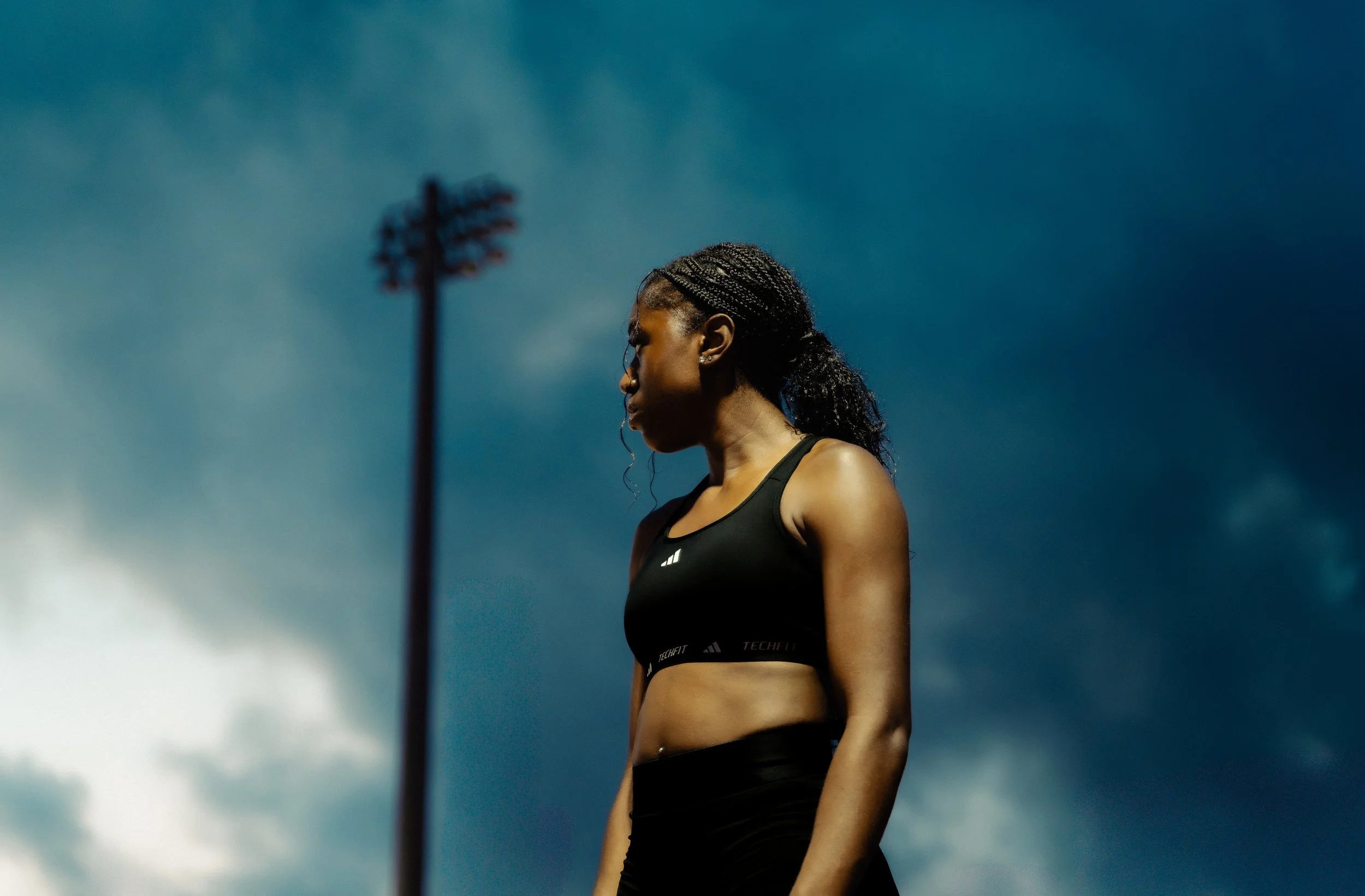 Editorial-style image of athlete in Adidas performance wear, framed against a blue South Florida sky — a balance of power and poise.