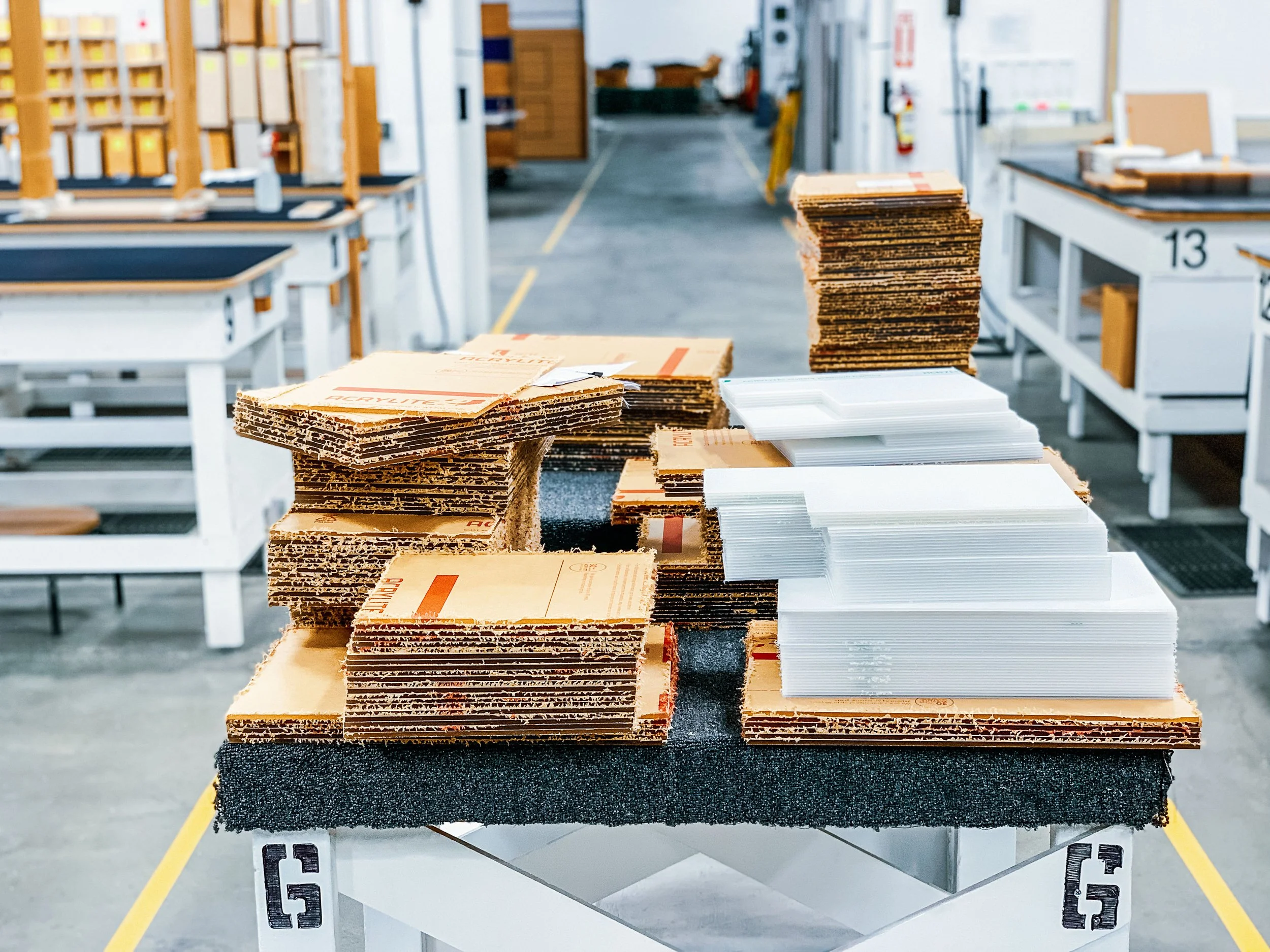 Stacks of clear cut-to-size acrylic panels ready for assembly.  Two different types of protective masking are used due to fabrication requirements.