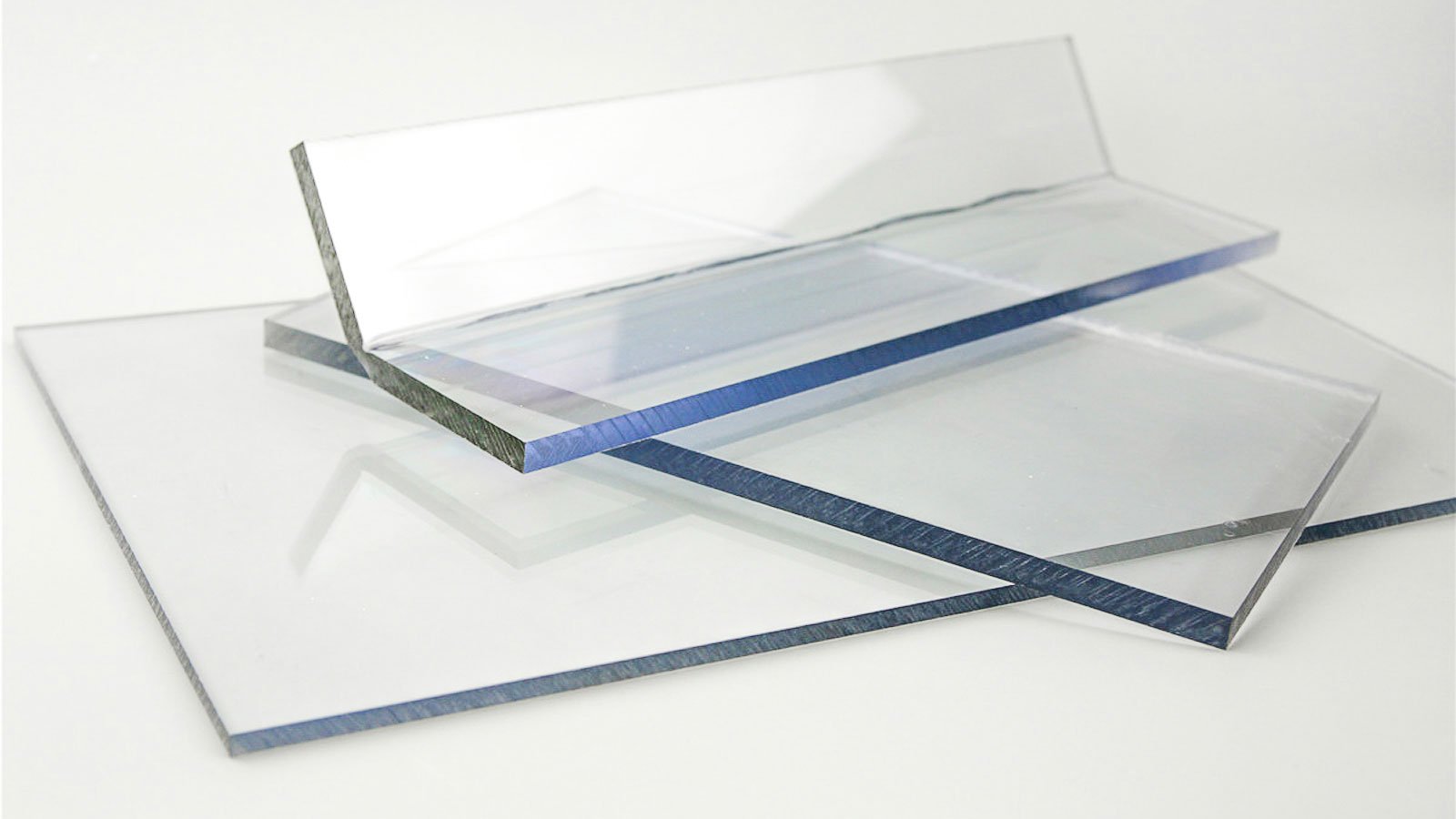 Stack of clear acrylic sheets on a white surface.