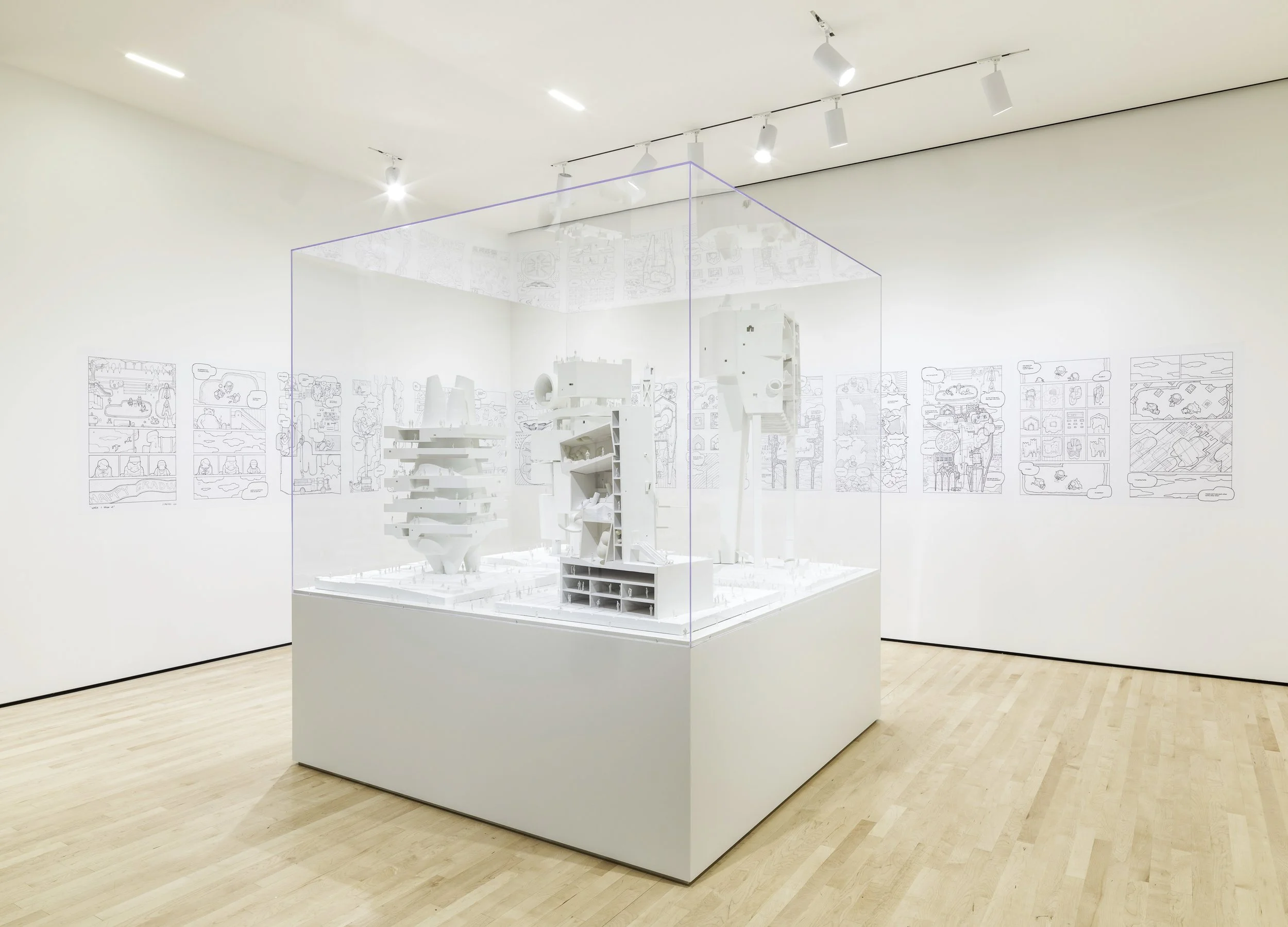 Oversized clear acrylci display case on top of a white painted plinth showcasing an architectural model.