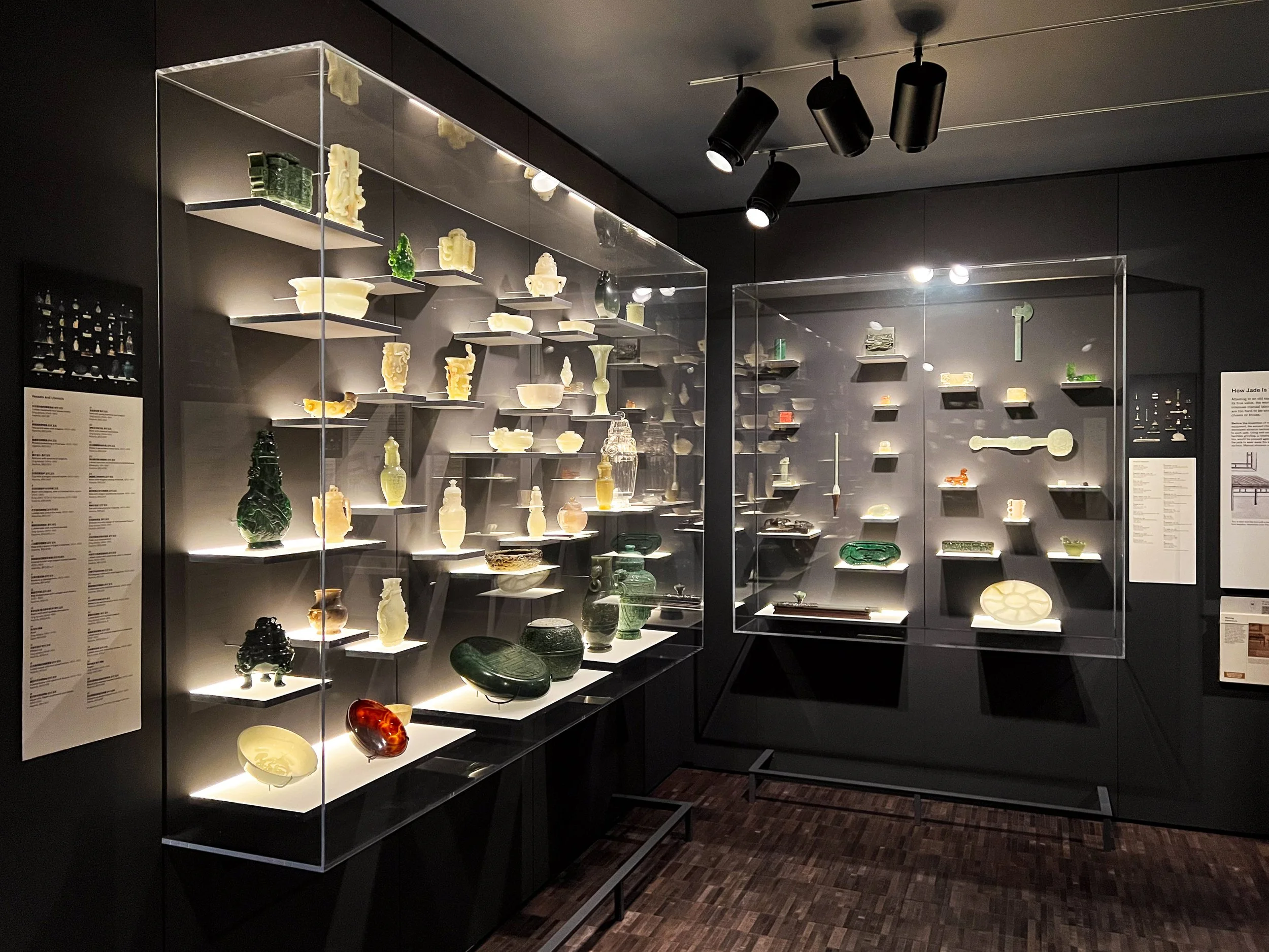 Museum gallery with wall-mounted acrylic display cases showcasing artifacts in a secure wall case system with uplit shelves.
