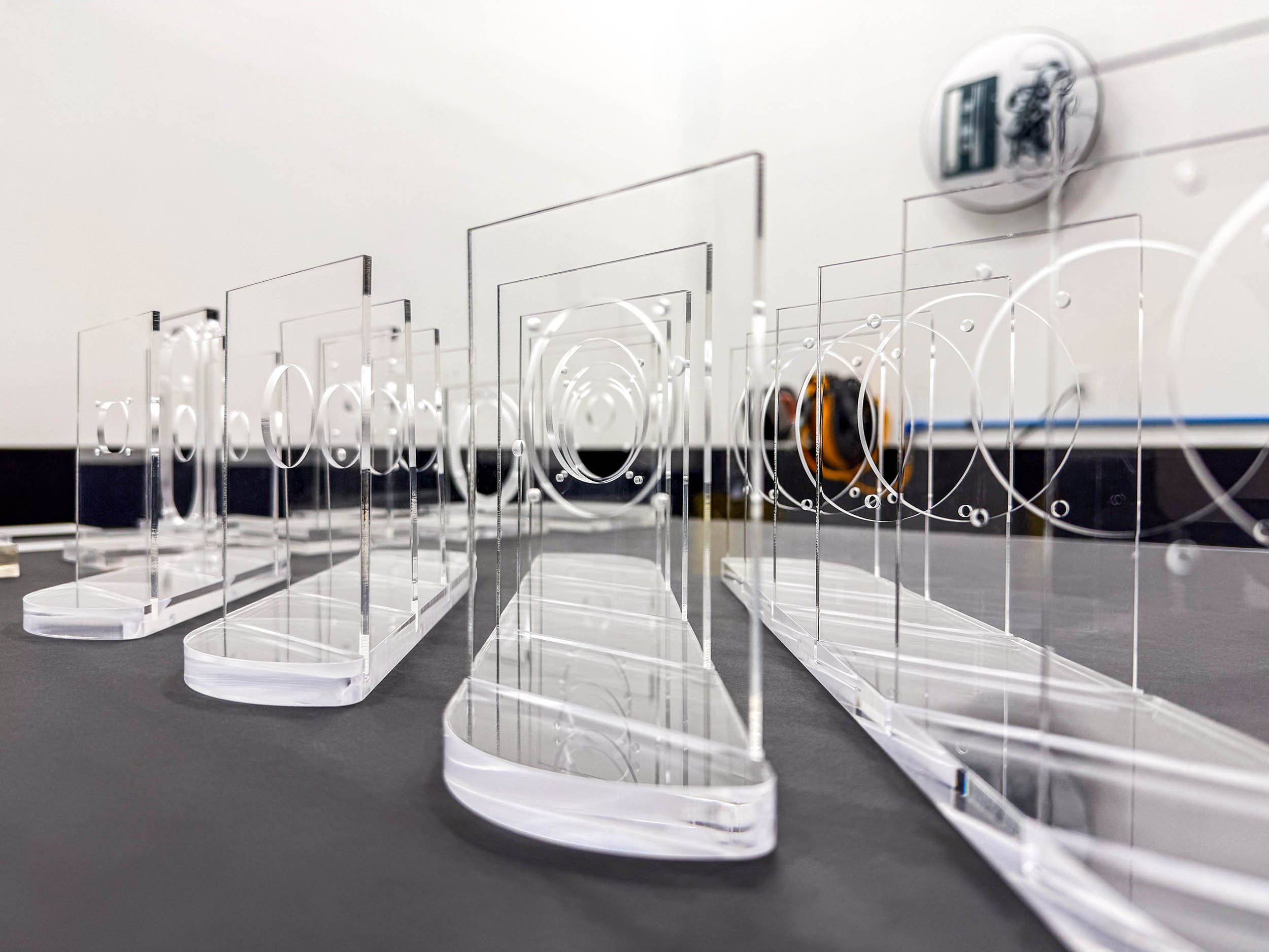 Multiple clear acrylic parts staged for repeatable production output and consistent quality.