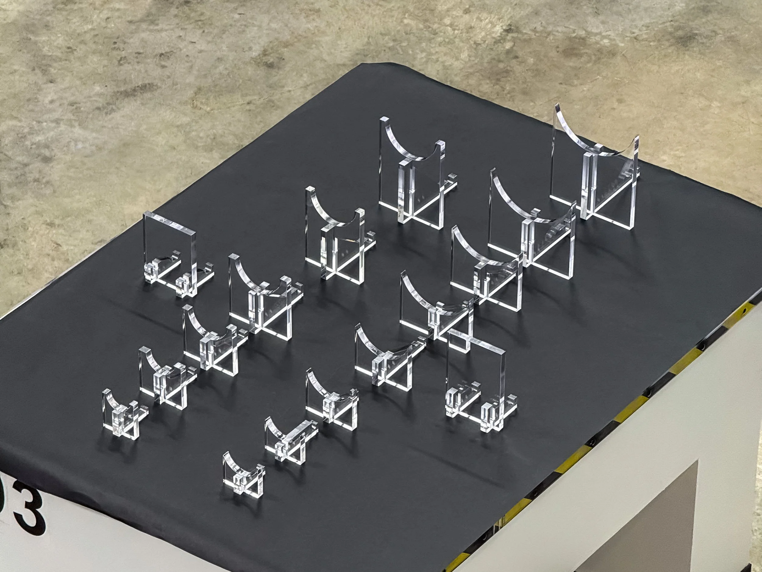 Assorted clear acrylic component variations organized for a multi-size production run.