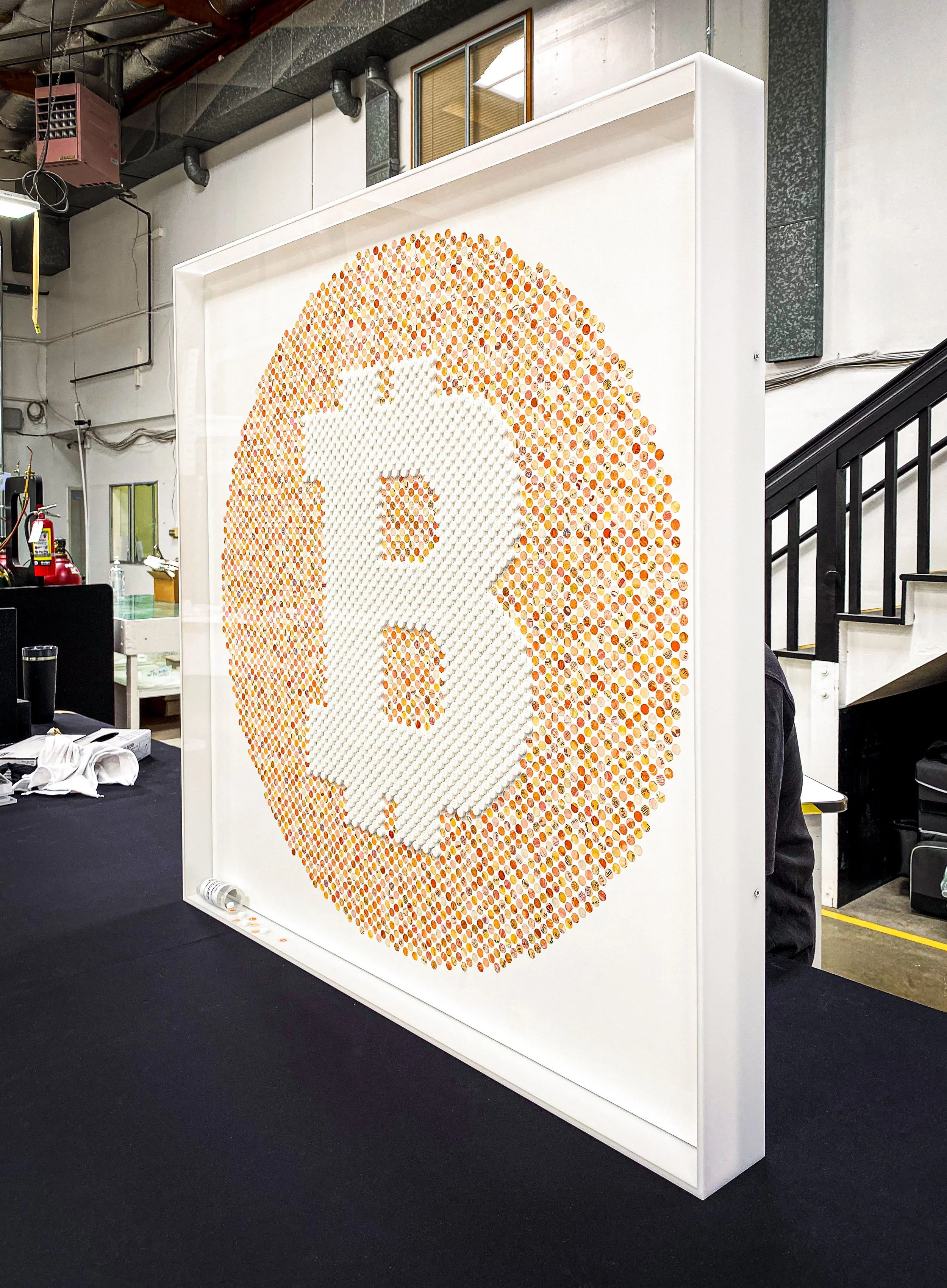 Modern Bitcoin artwork inside a clear acrylic wall mounted display case with matte while acrylic sides.