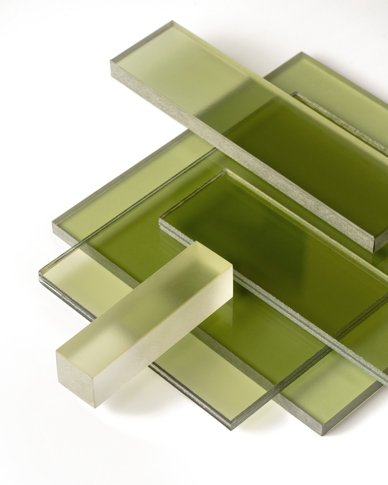 Stack of translucent green glass sheets on a white background