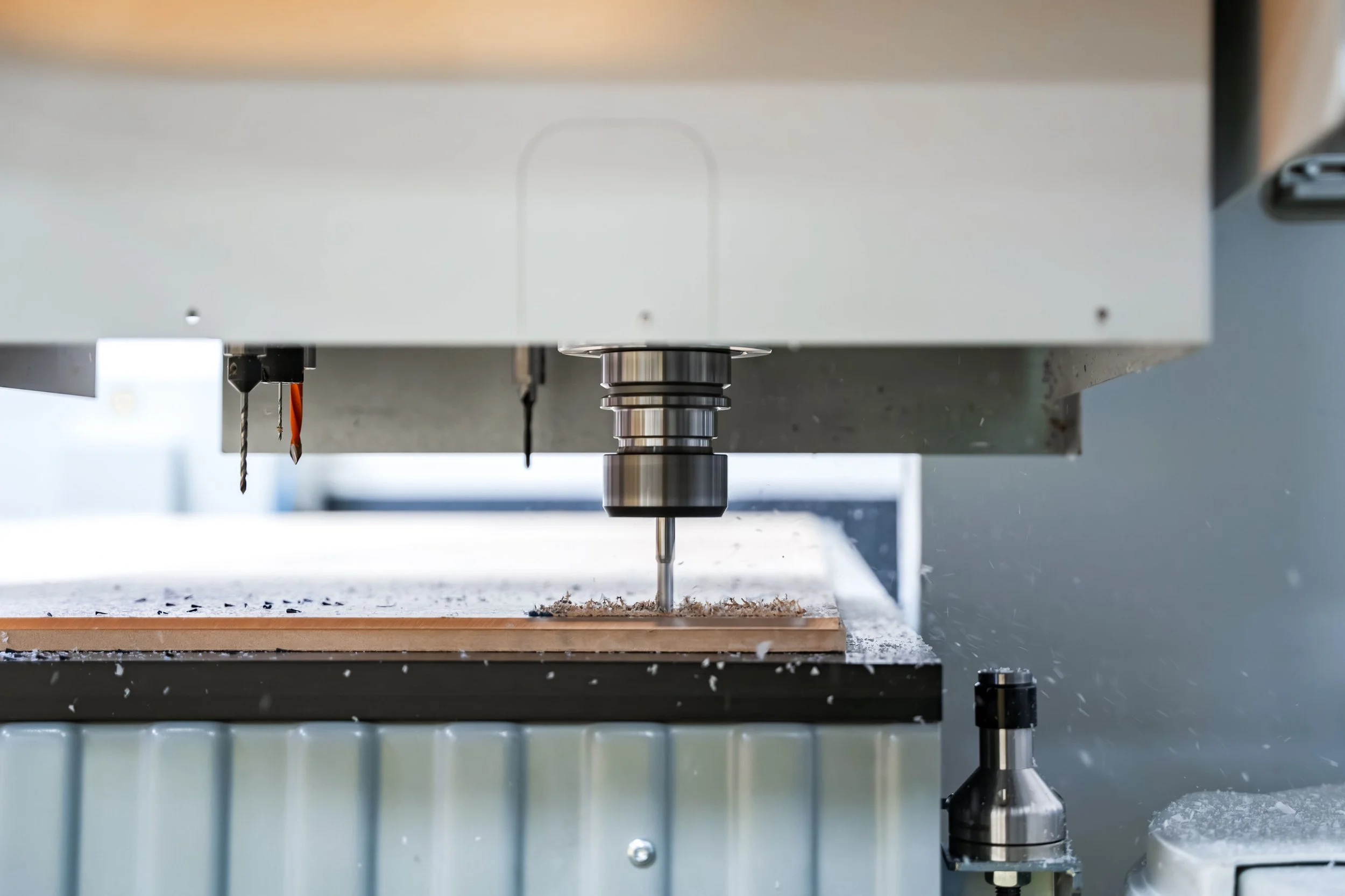 Cnc router in the process of cutting a sheet of acrylic into small shapes.