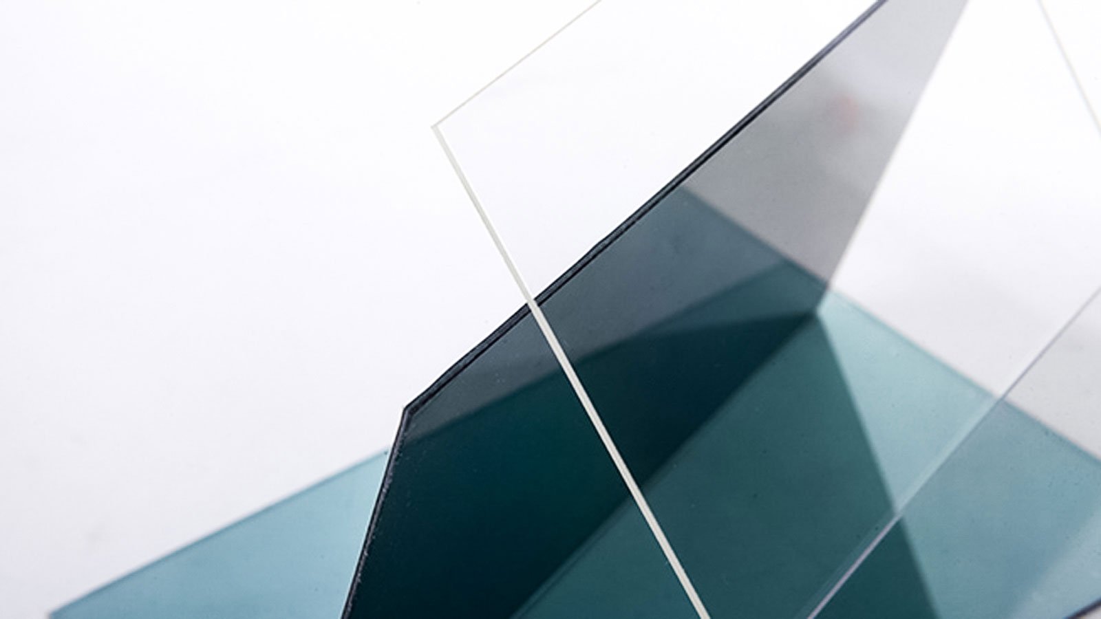Close-up of overlapping glass panels, showcasing transparent and tinted surfaces.