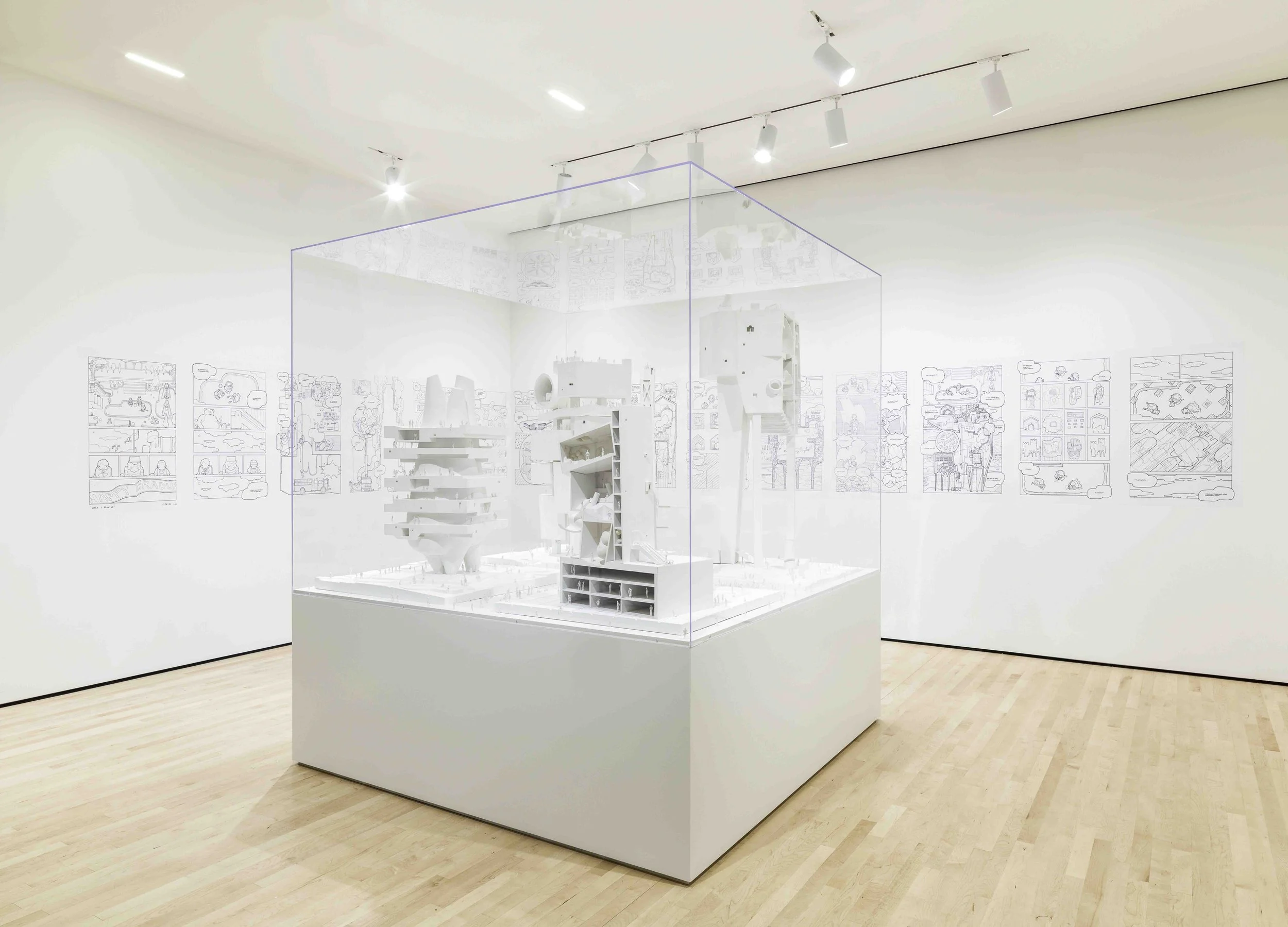 An exhibit at SFMOMA showing an architectural model.  The model in inside of a large clear acrylic display case that sits over an MDF pedestal painted matte white.