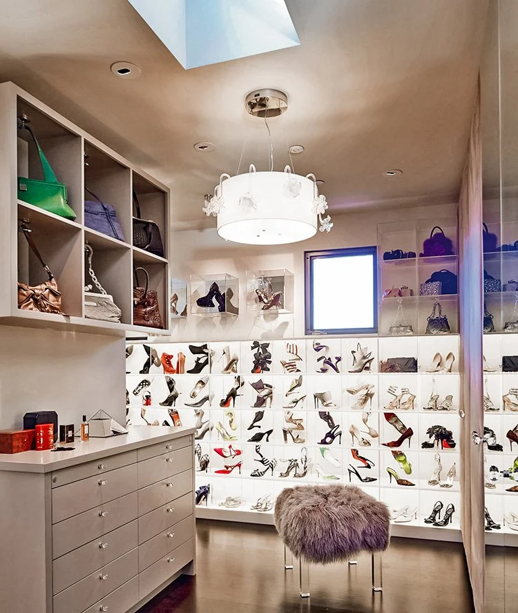 Luxury closet and storage installation featuring clear acrylic display components, integrated lighting, and custom built-in drawers.