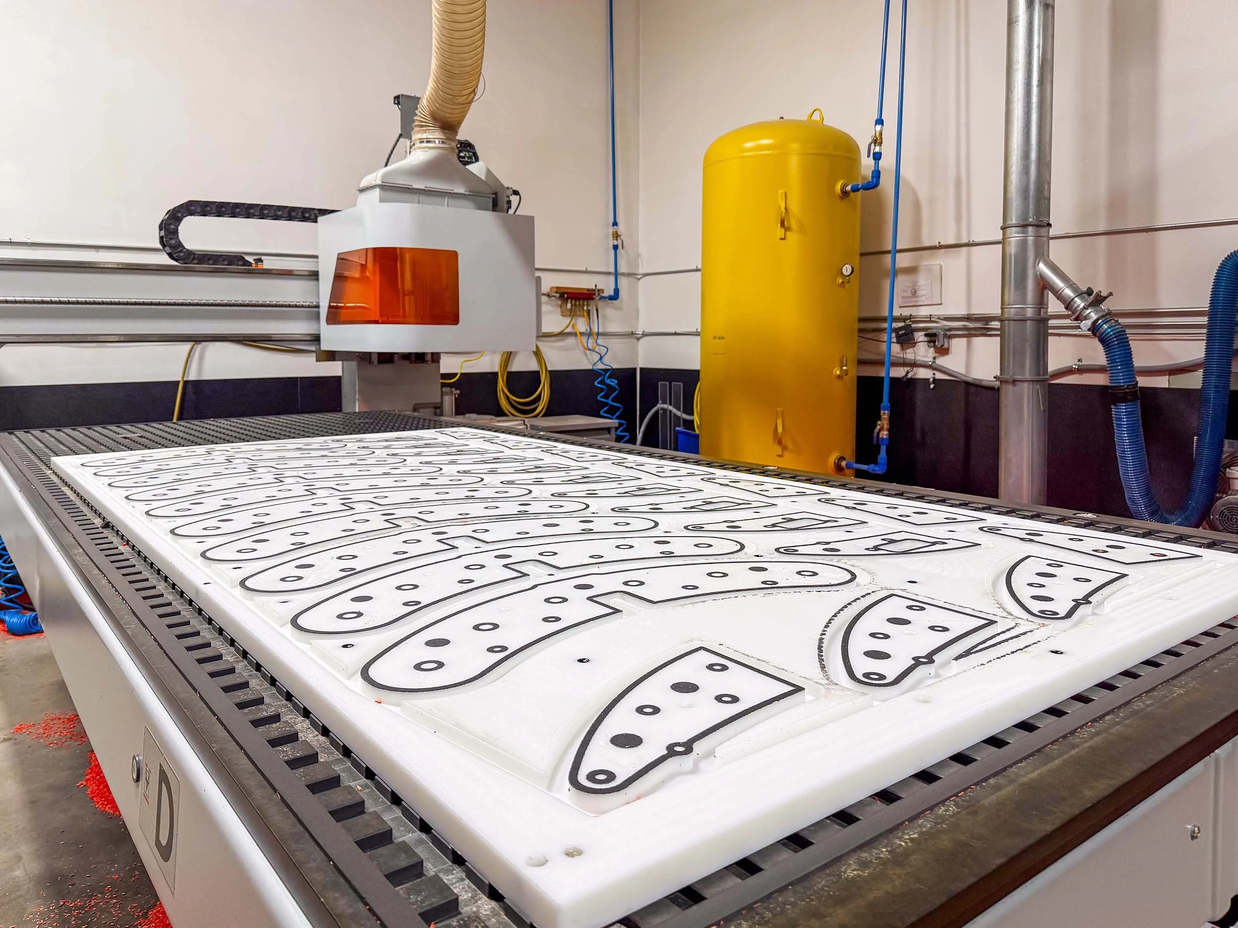 Fixture table setup for fast, repeatable machining of small plastic parts on a CNC router.