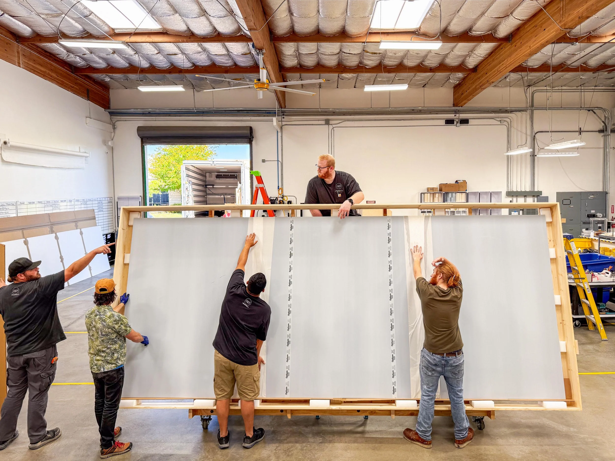 Fabricators at Architectural Plastics, Inc. facility in Petaluma, CA doing final quality control check on a seamed Tru Vue Optium panel.