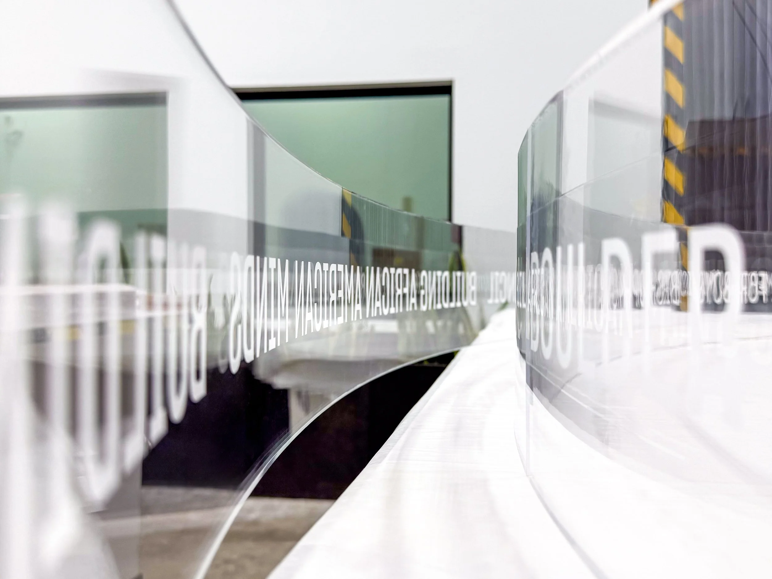 Close up detail of custom thermoformed clear acrylic panels with white lettering applied to them.