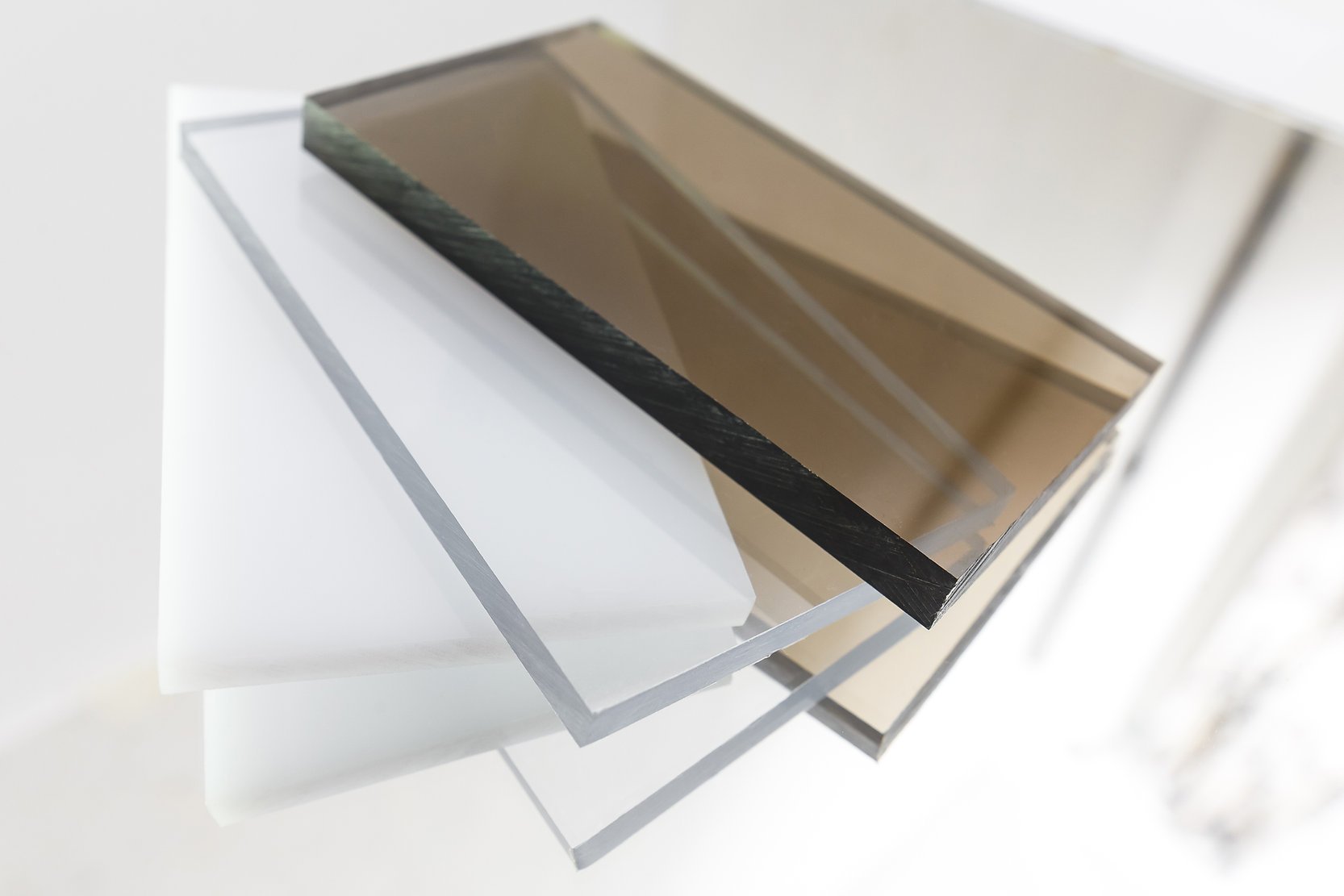 Stack of transparent and translucent acrylic sheets in various colors.