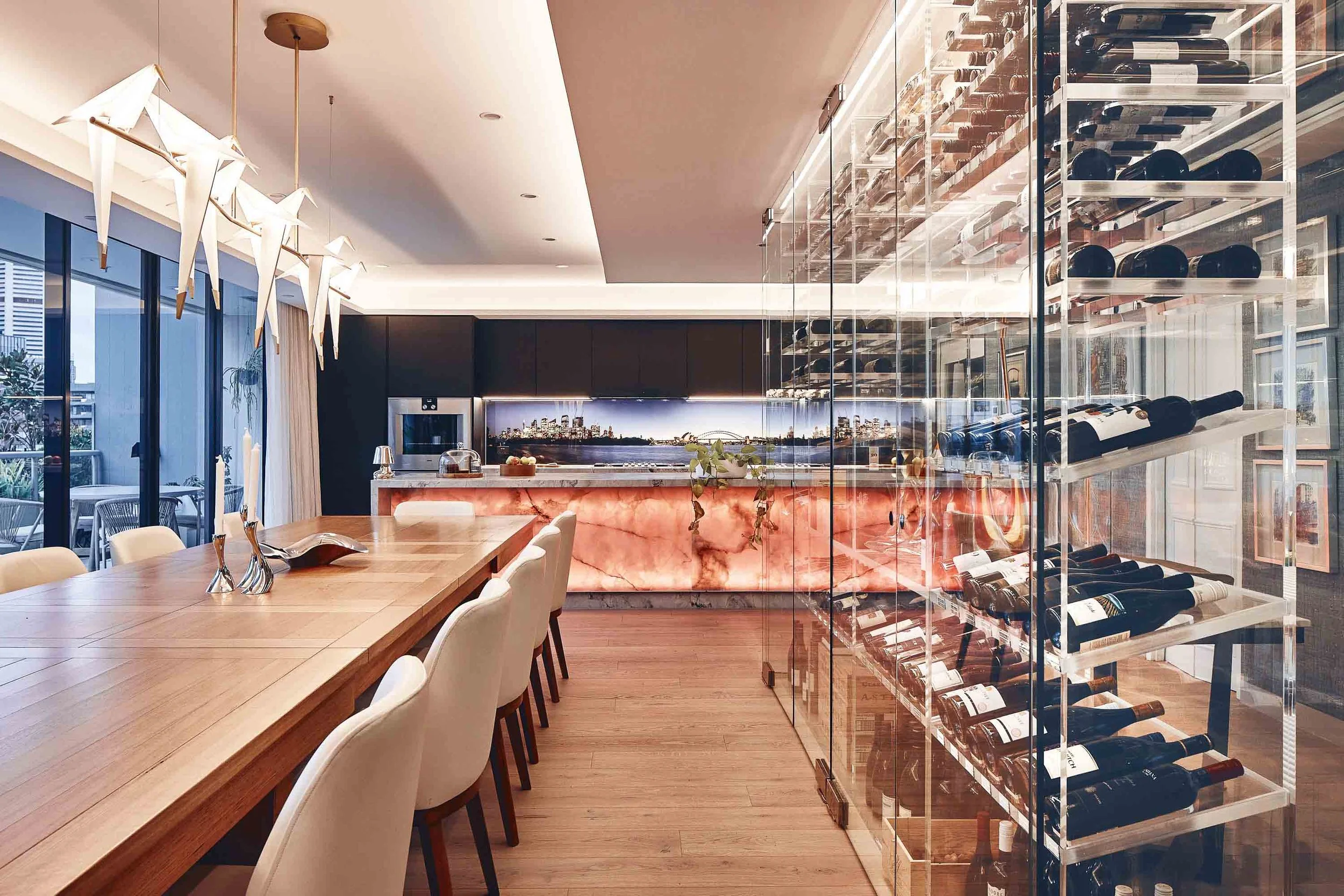 Glass enclosed custom acrylic wine cellar installation with clear acrylic bottle storage and integrated lighting in a modern residential space.