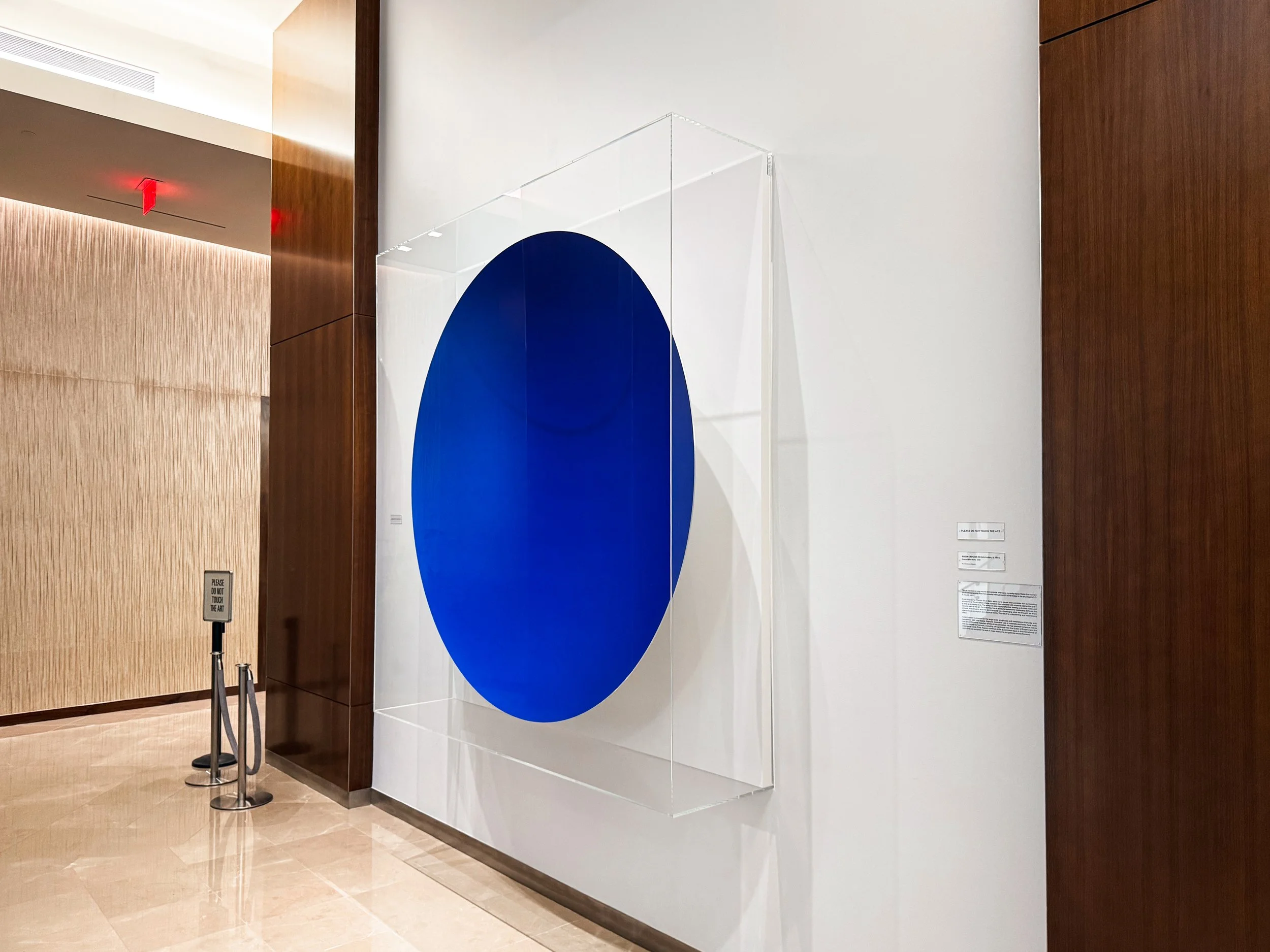 Side view of an Optium museum acrylic wall case display with custom white painted backer for an Anish Kapoor art installation at the Dallas Cowboy's AT&T Stadium.