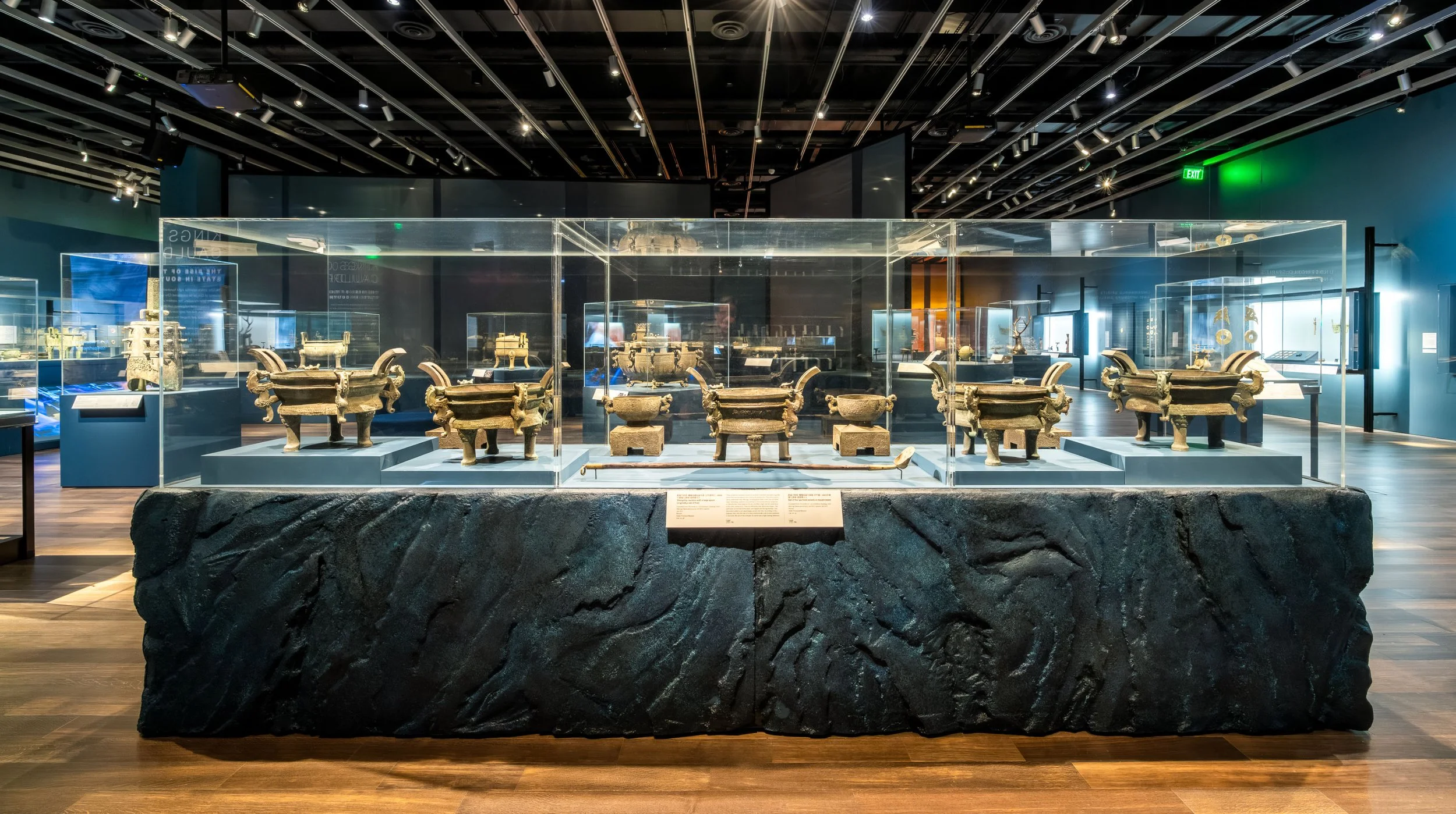 Multi-case museum acrylic display on an artistic texture pedestal plinth designed for secure exhibit presentation of Chinese artifacts.