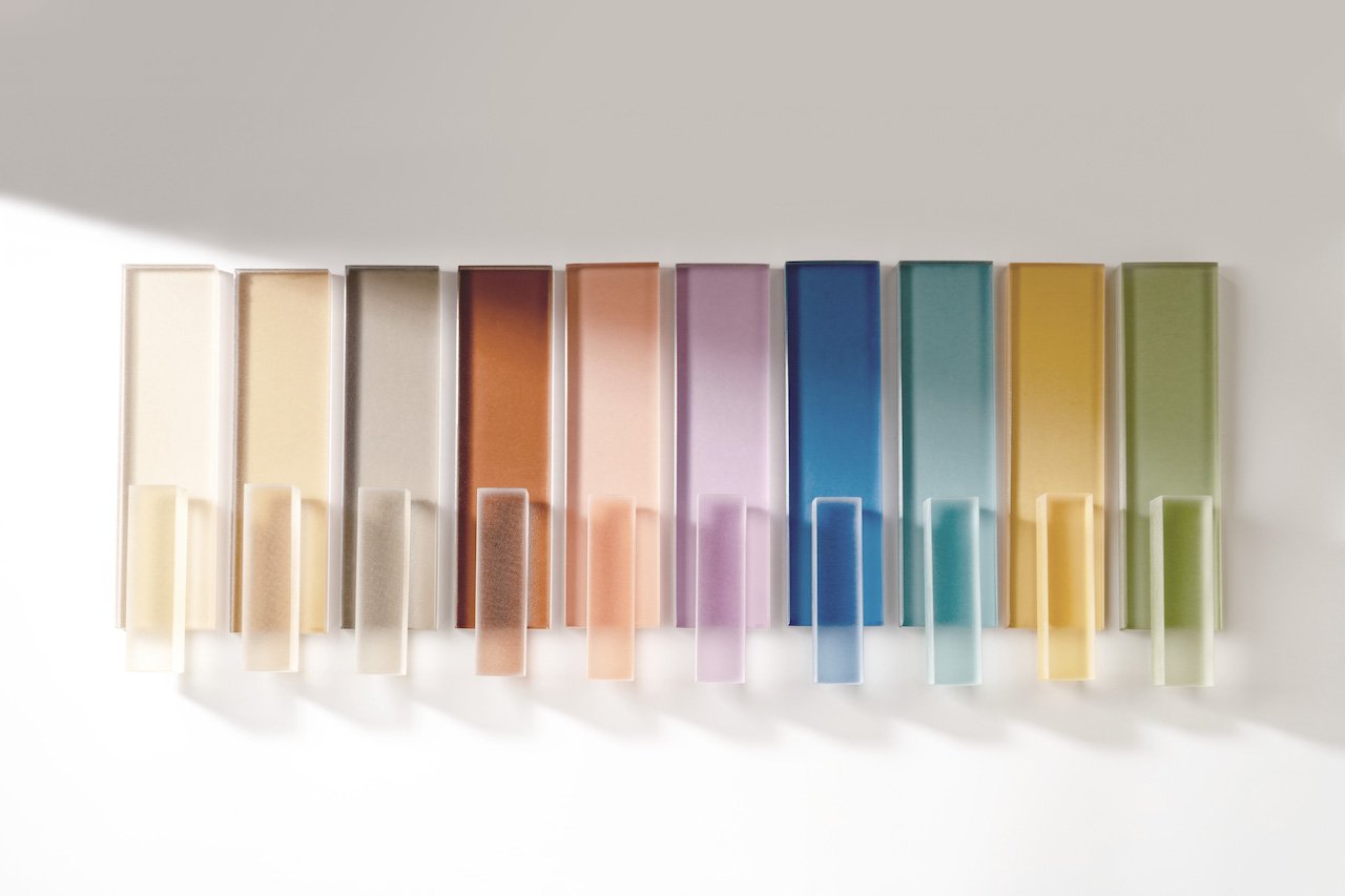 Colorful vertical glass panels in various shades on a white background.