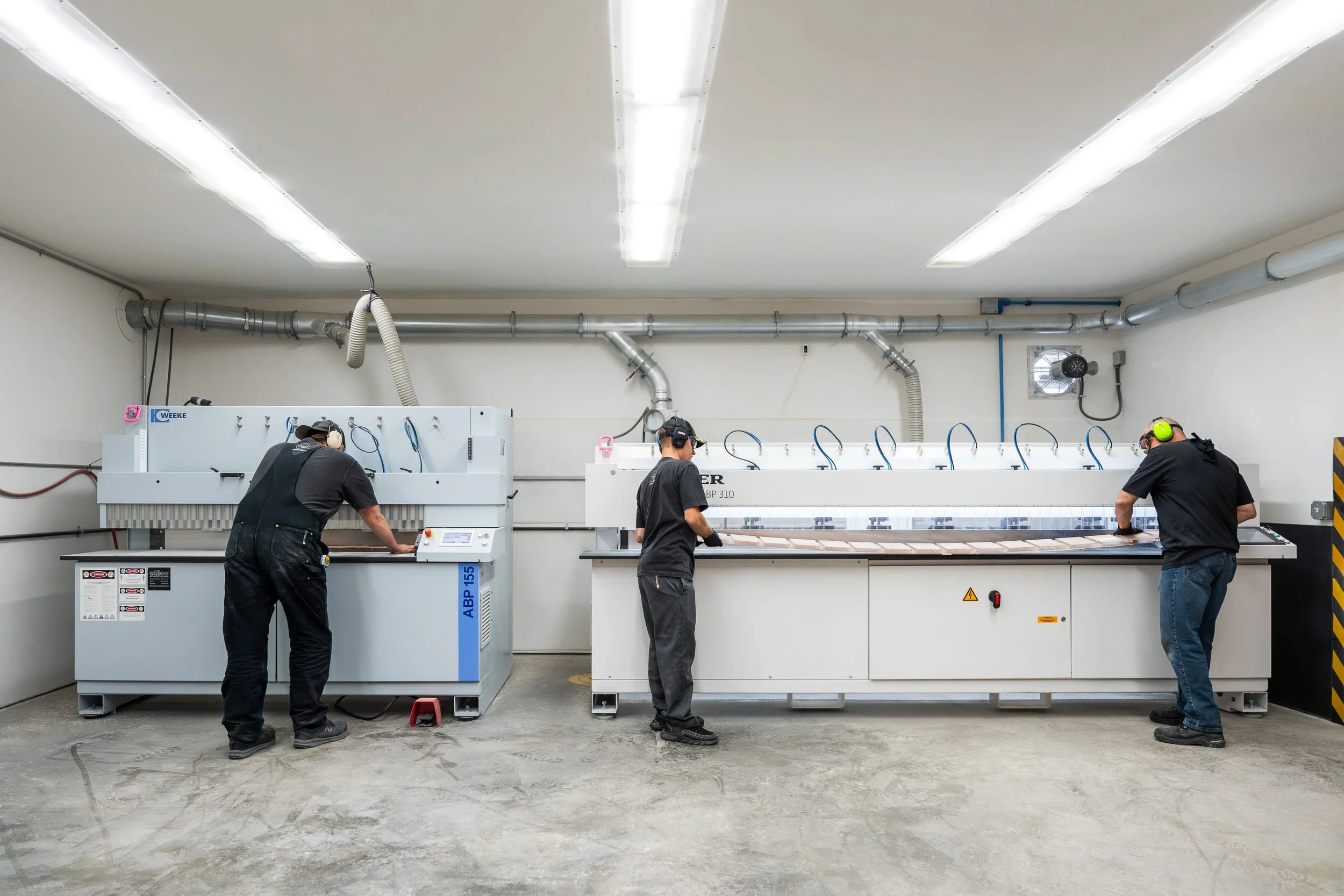 CNC milling production floor machining plastic parts and panels with multiple operators and repeatable programs.