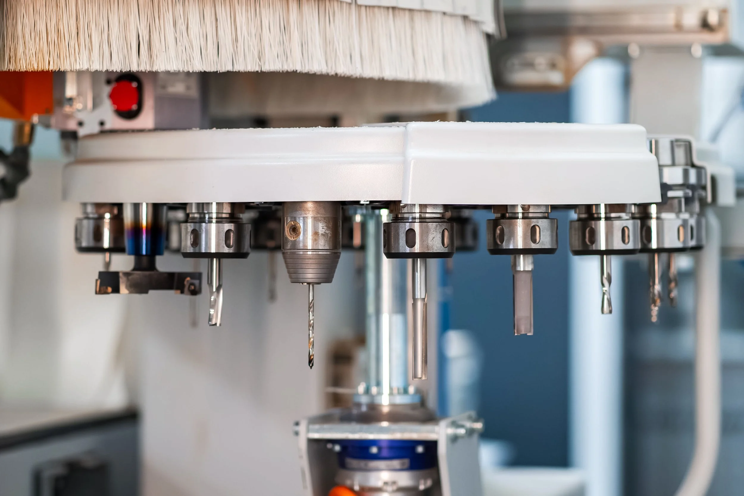 Cnc router tool carousel holding several types of cutters and drill bits ready for production.