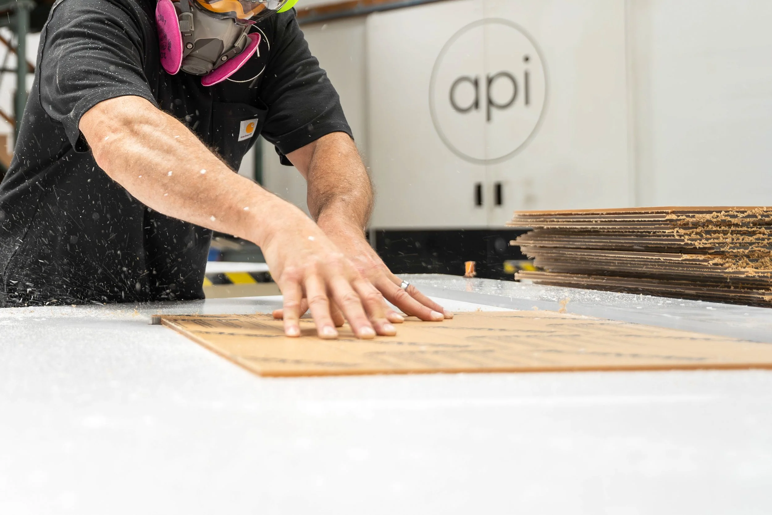 Plastic fabricator using a table router to add extra detailing to acrylic panels.