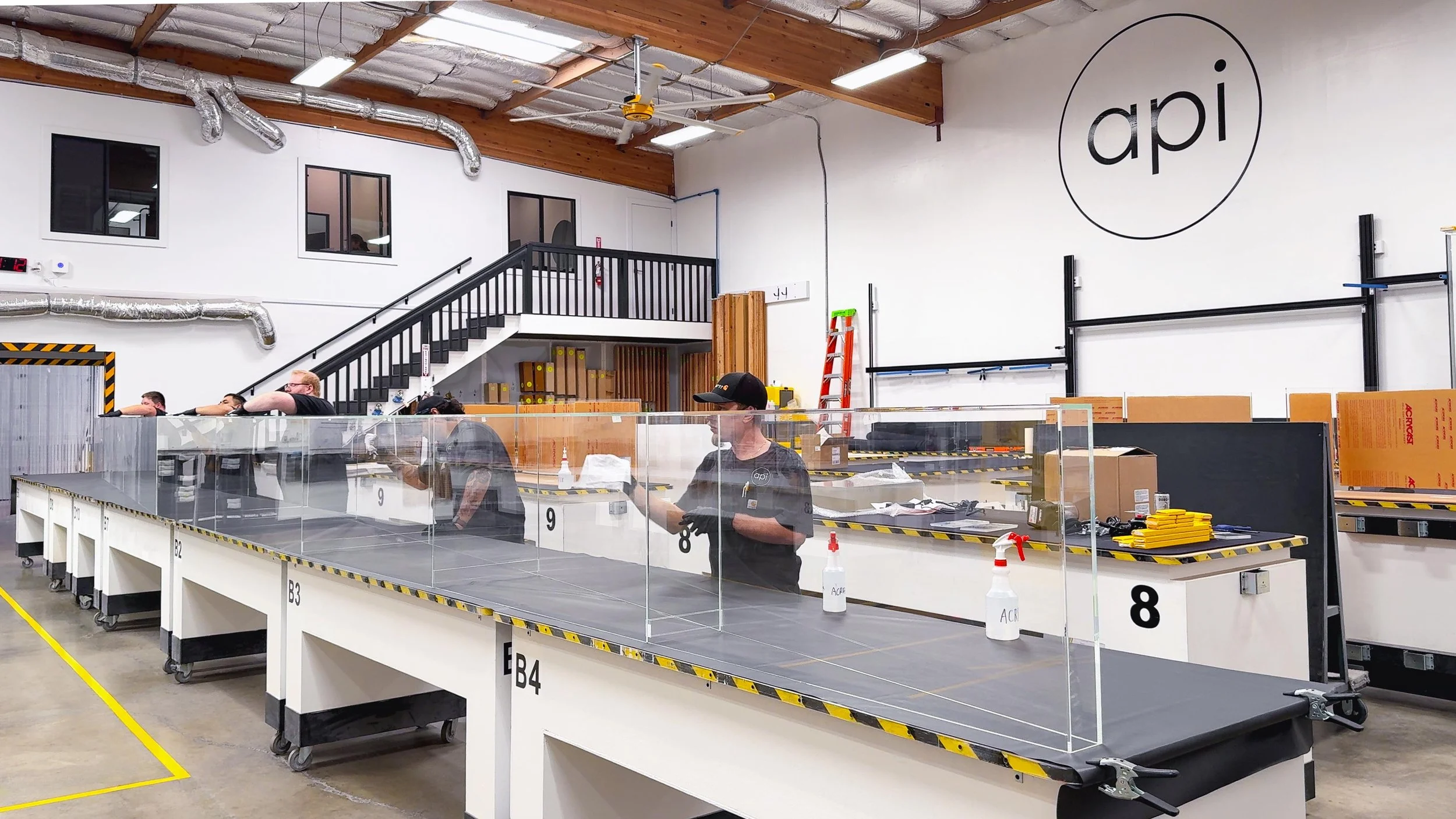 Multiple technicians working on a 32 foot long display case assembly at the Architectural Plastics, Inc. facility.